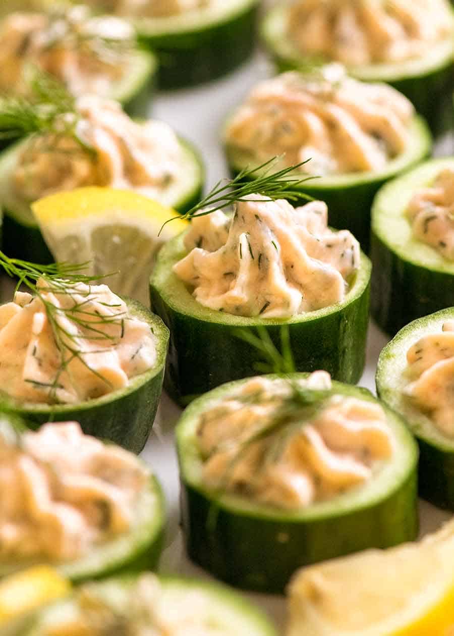 Primer plano de canapés de pepino con mousse de salmón ahumado adornado con eneldo