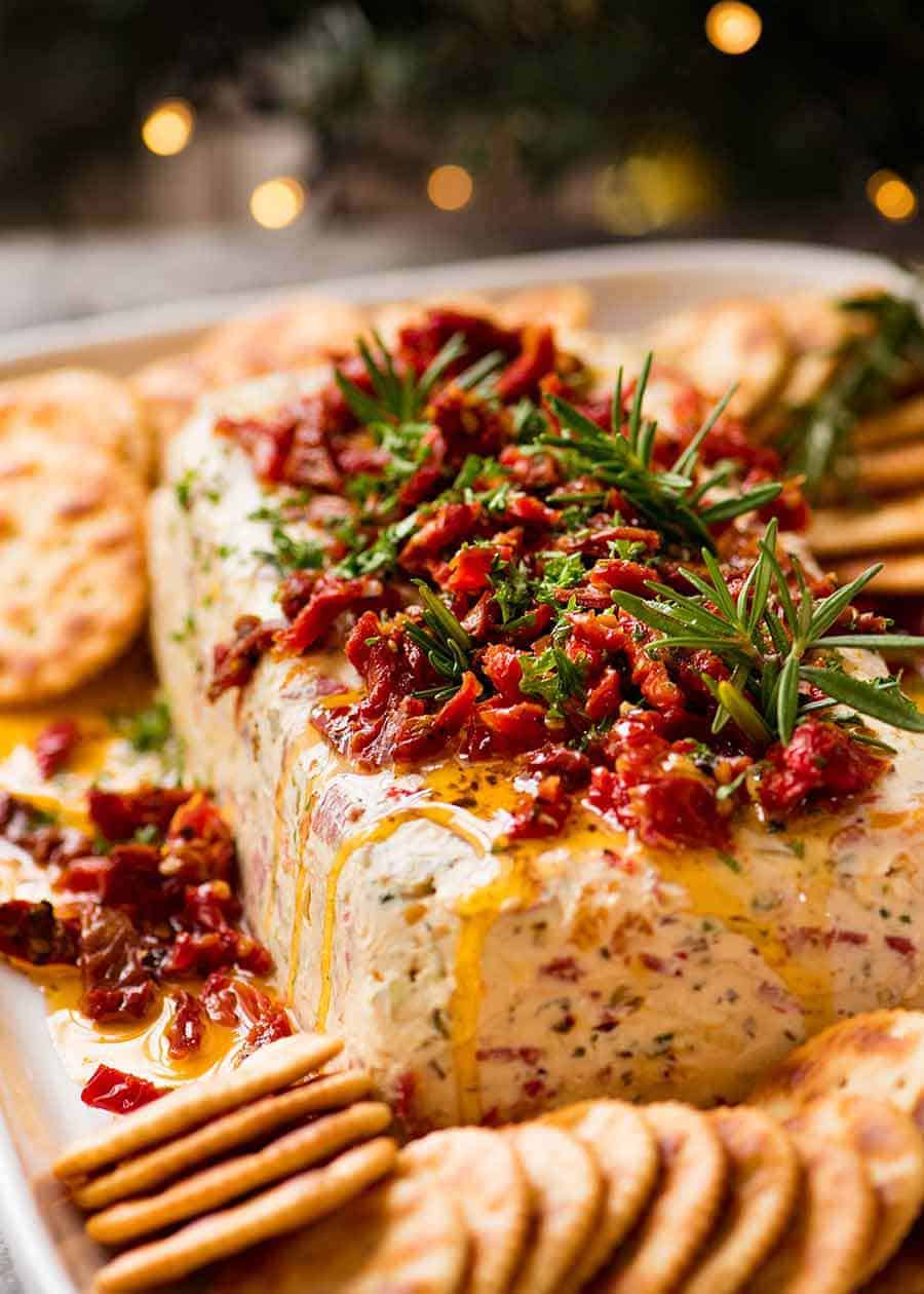 Aperitivo de Navidad Registro de queso italiano con árbol de Navidad en el fondo - aperitivo festivo para las fiestas