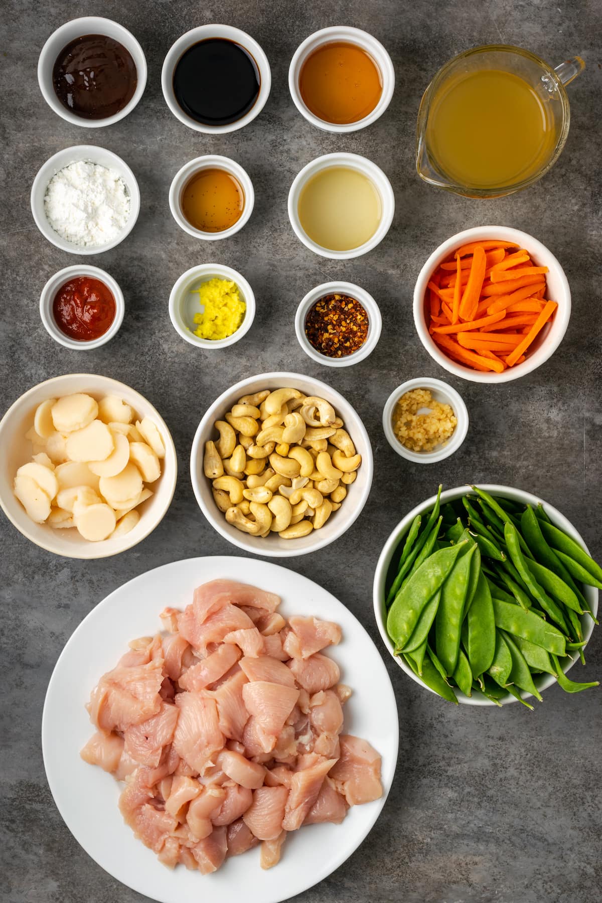 ¡Este pollo con anacardos de 25 minutos es una alternativa fácil a la comida para llevar! Hecho de jugoso pollo cocinado con verduras en una sabrosa salsa salteada. Los ingredientes para el salteado de pollo con anacardos.