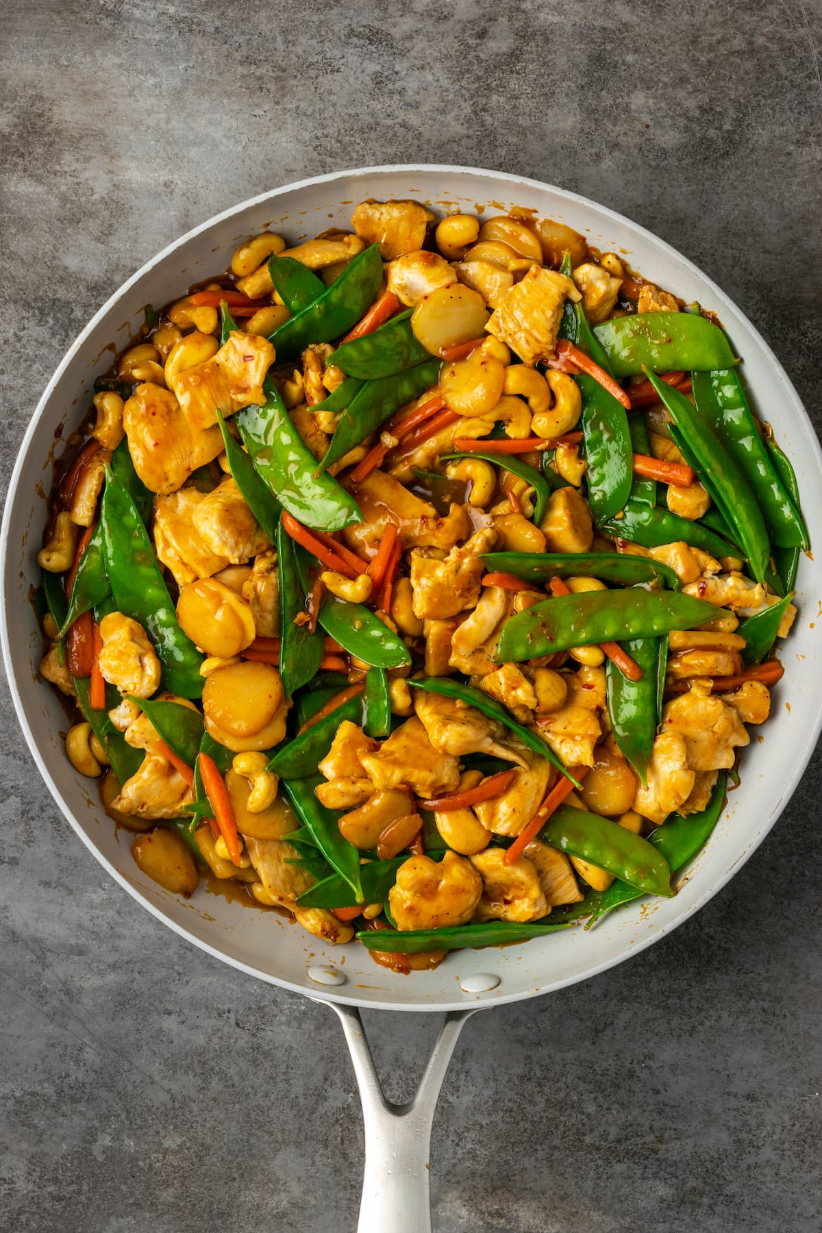 ¡Este pollo con anacardos de 25 minutos es una alternativa fácil a la comida para llevar! Hecho de jugoso pollo cocinado con verduras en una sabrosa salsa salteada. Salteado de pollo con marañón en una sartén.