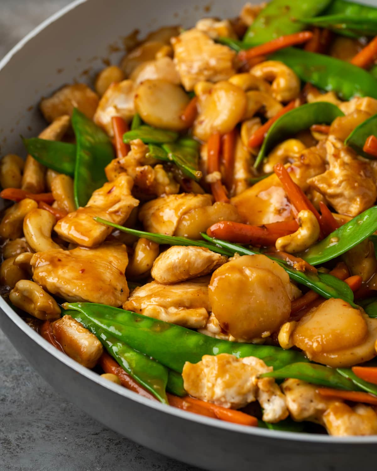 ¡Este pollo con anacardos de 25 minutos es una alternativa fácil a la comida para llevar! Hecho de jugoso pollo cocinado con verduras en una sabrosa salsa salteada. Ciérrese para arriba del pollo del anacardo en un cuenco.