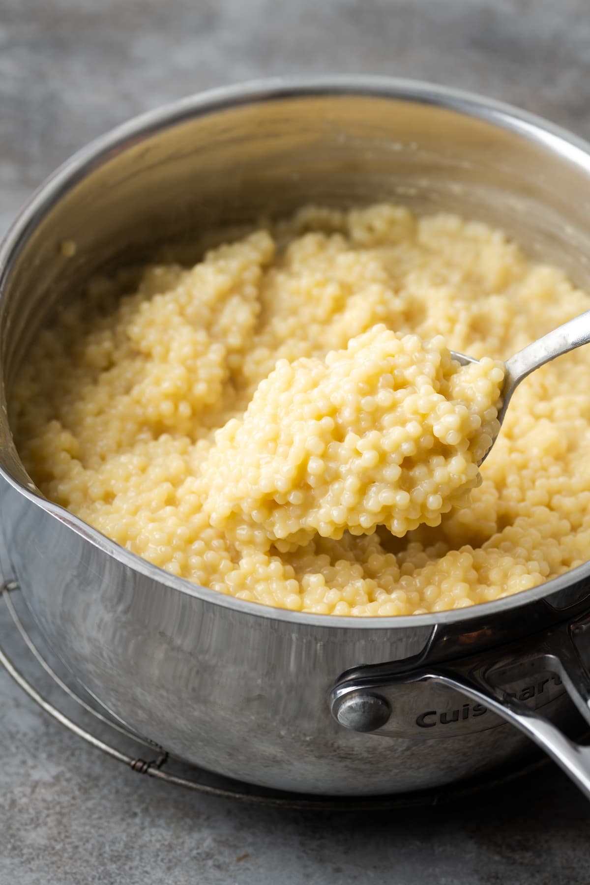 Pastina cremosa siendo revuelta en una olla.