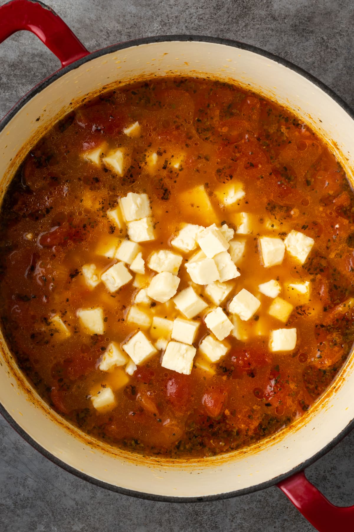 Queso feta agregado a una olla de sopa de tomate.