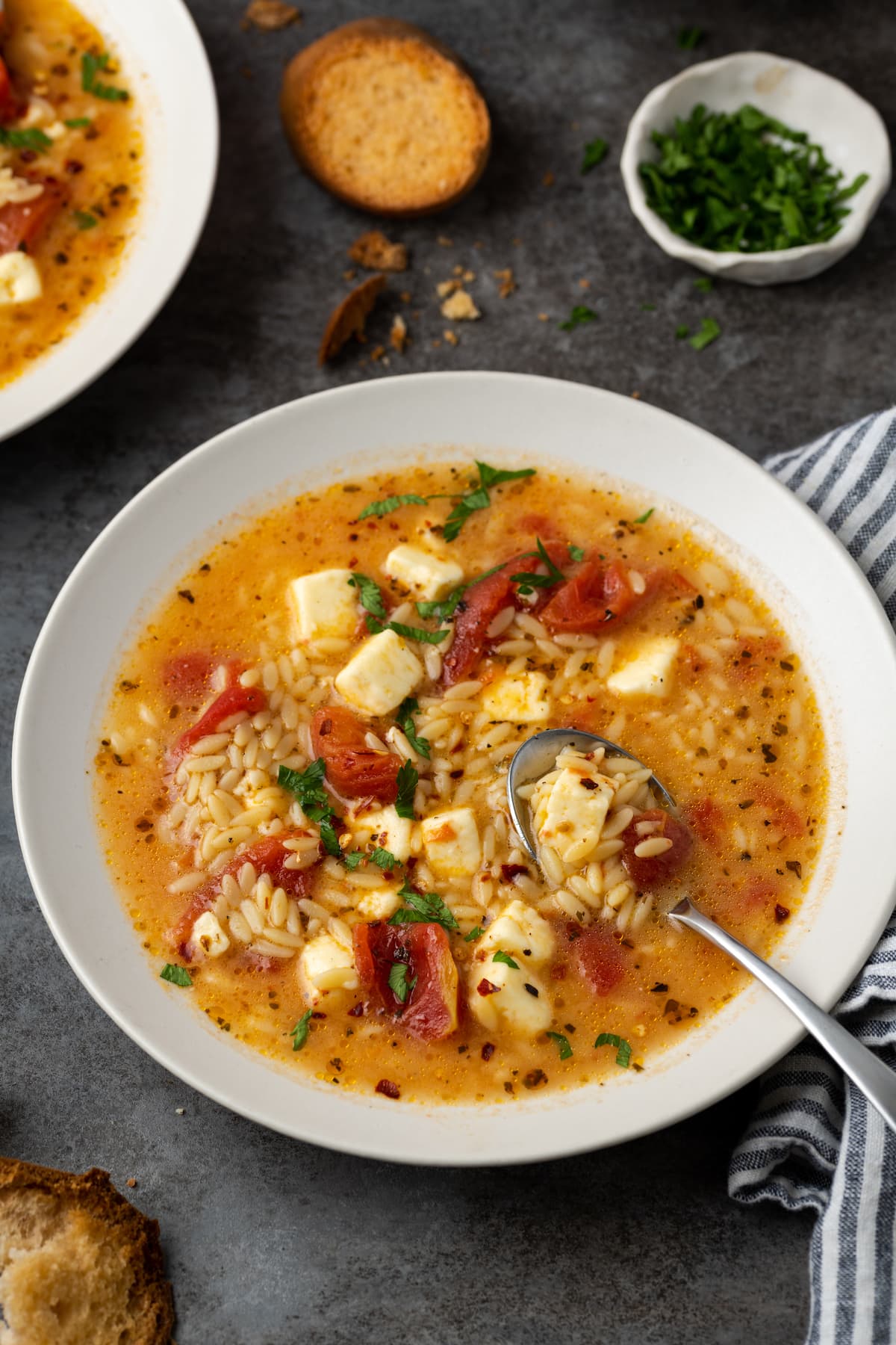 Vista aérea de un tazón de sopa griega de tomate feta con una cuchara.