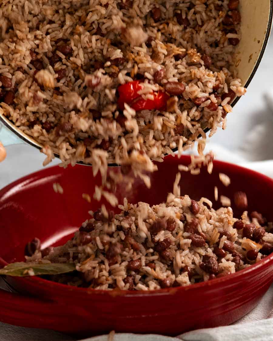 Verter arroz con coco jamaicano cocido y guisantes (frijoles) en un bol