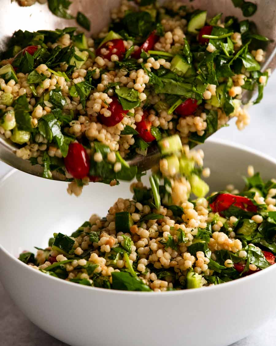 Verter la ensalada de cuscús de perla en un tazón para servir