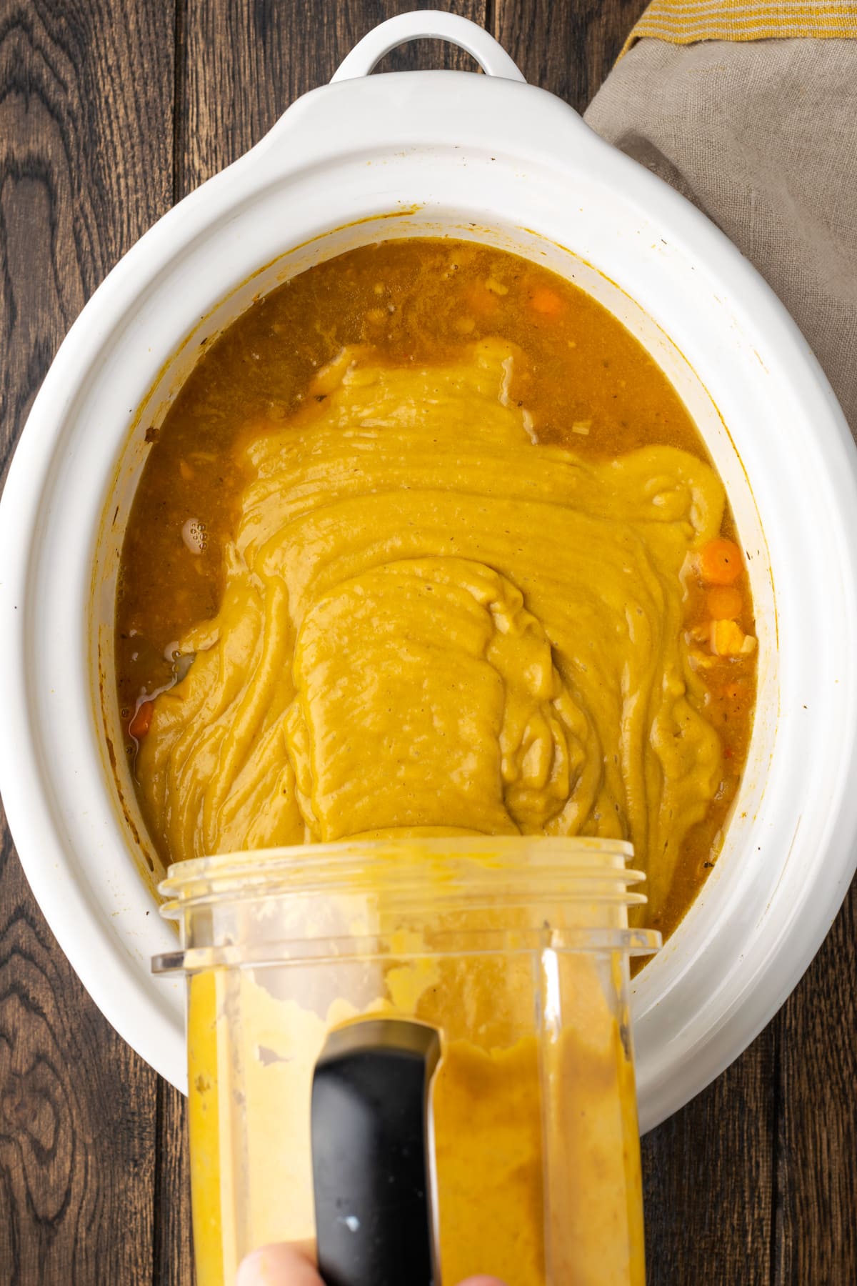 Los ingredientes de la sopa de lentejas en puré se vuelven a verter en la olla de cocción lenta con el resto de la sopa.