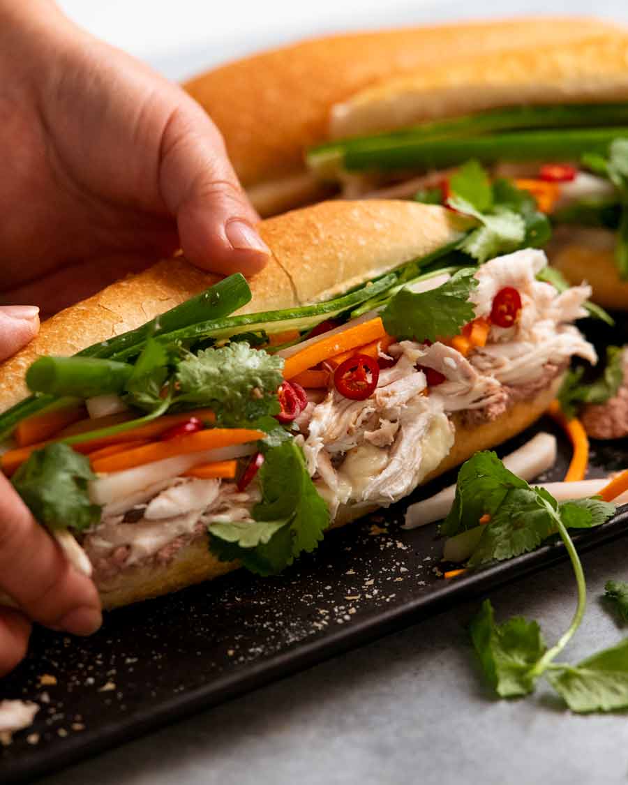 Mano recogiendo pollo banh mi