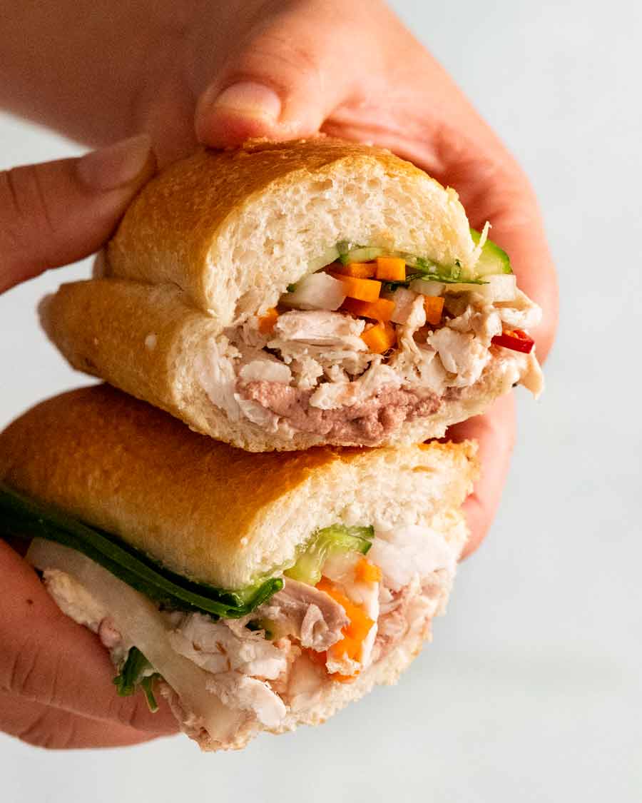 Mano sosteniendo corte abierto Chicken banh mi
