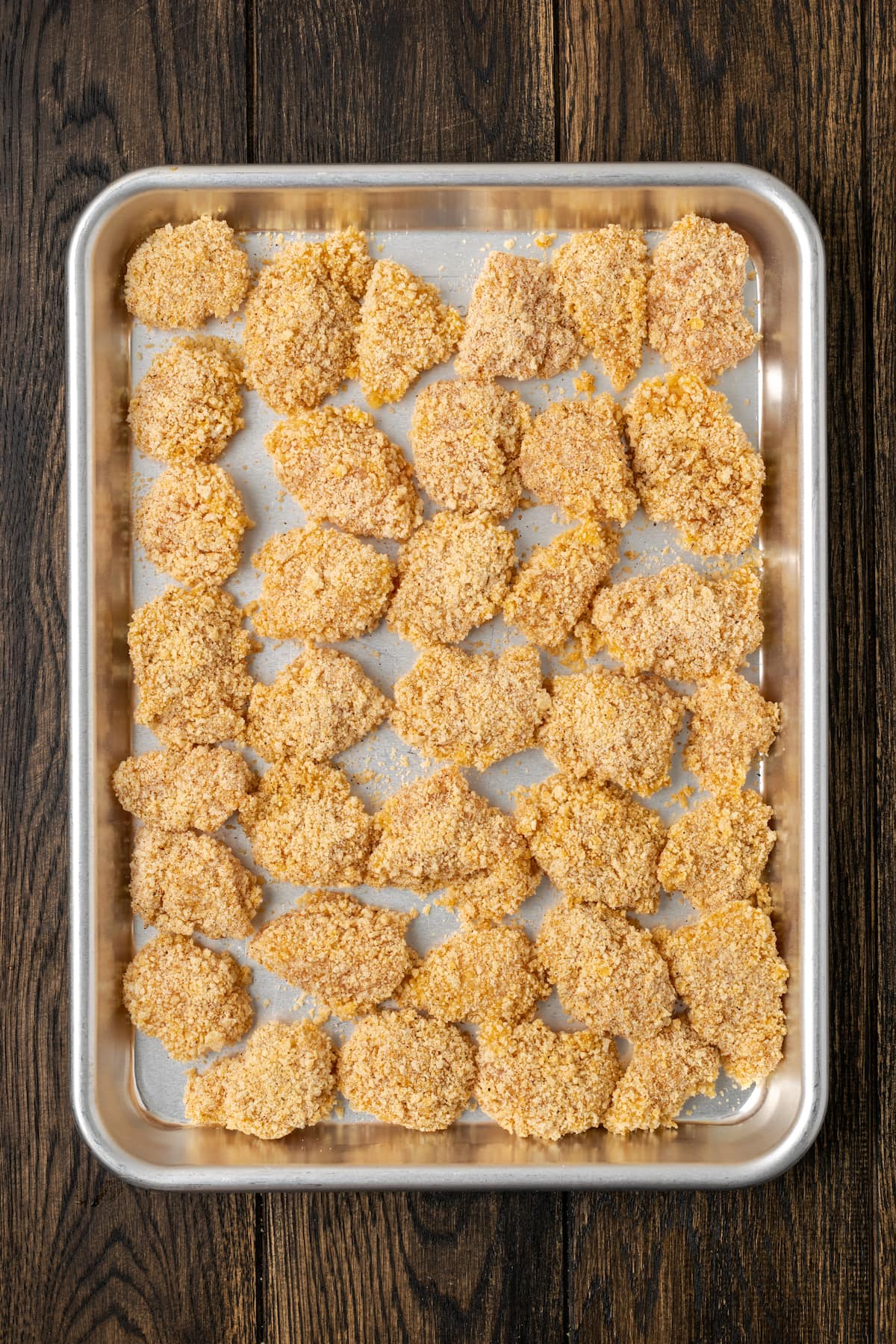 Crispy Air Fryer Popcorn Chicken es irresistiblemente crujiente por fuera y jugoso por dentro, ¡listo en 20 minutos de principio a fin! Nuggets de pollo empanizados en una bandeja para hornear.