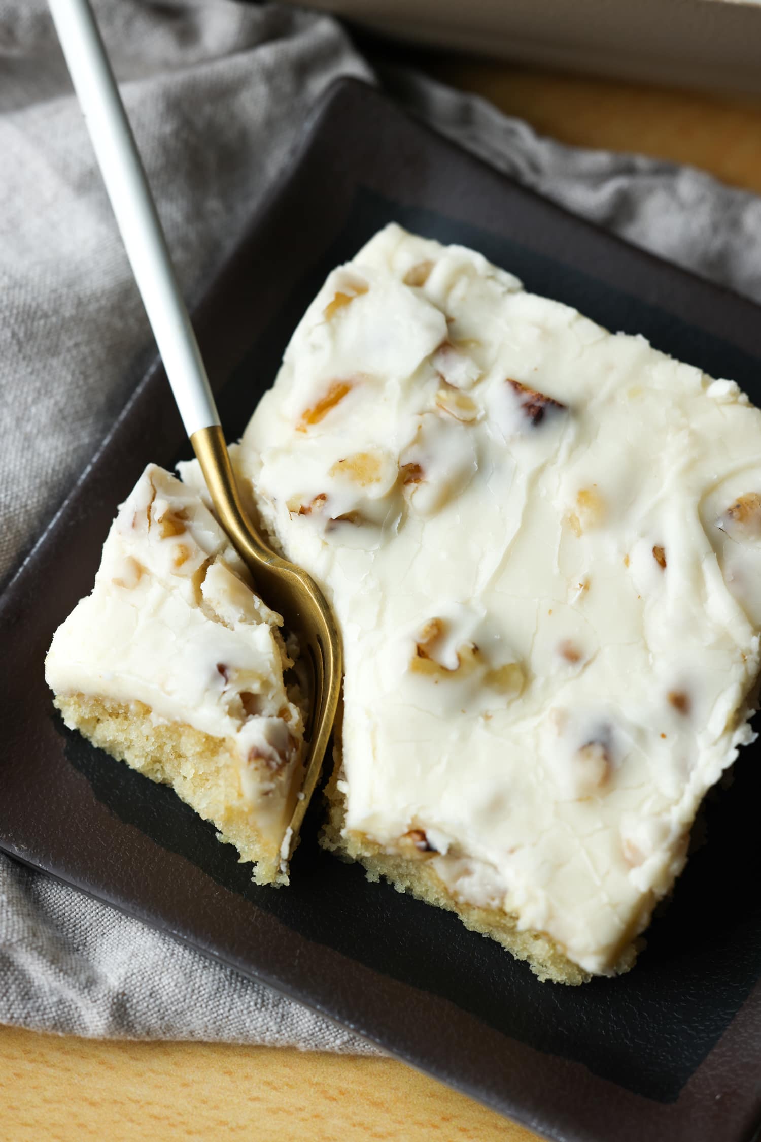 un tenedor cortando una rebanada de White Texas Sheet Cake en un plato