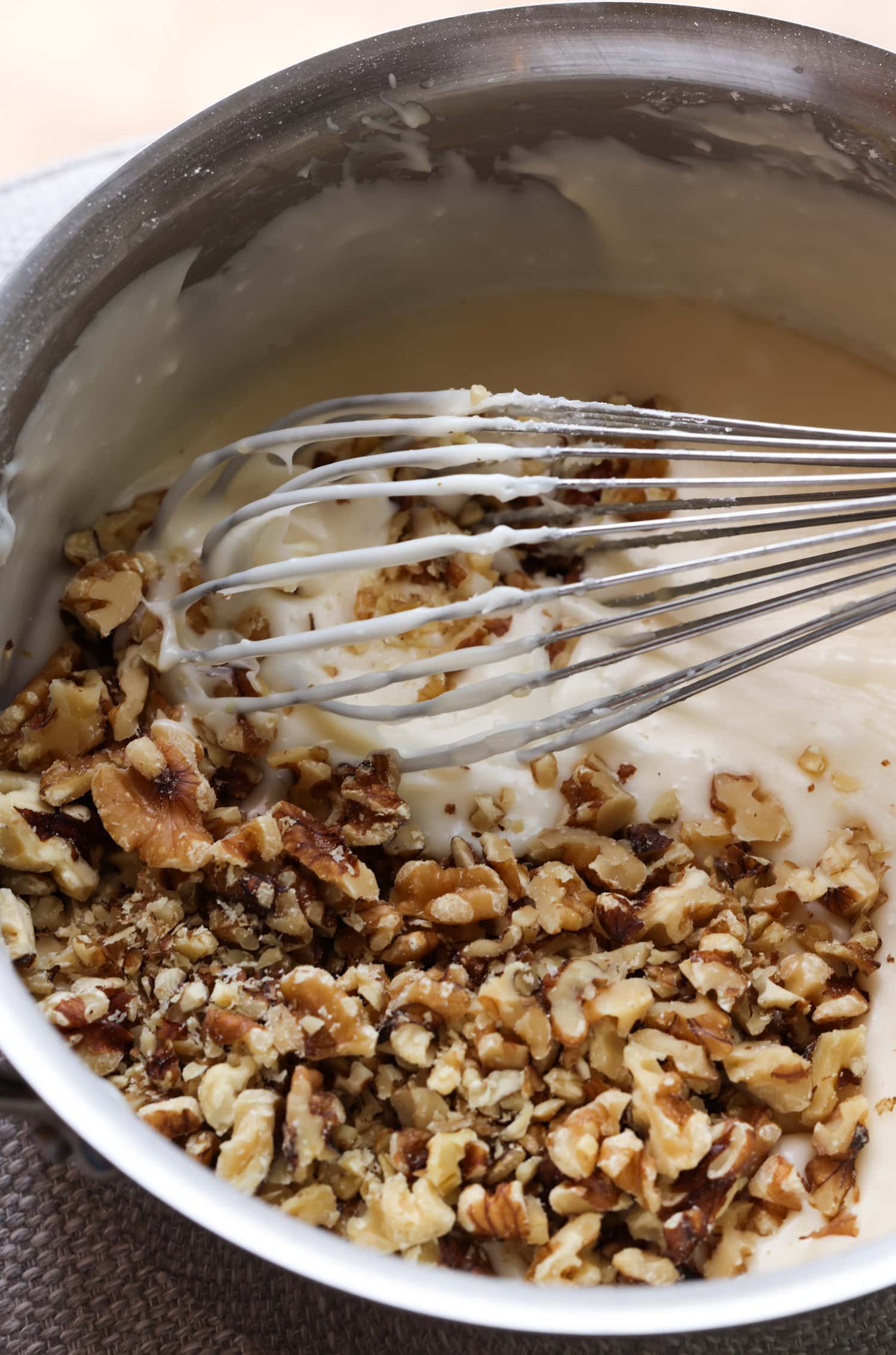 Mezclar nueces en glaseado blanco con un batidor
