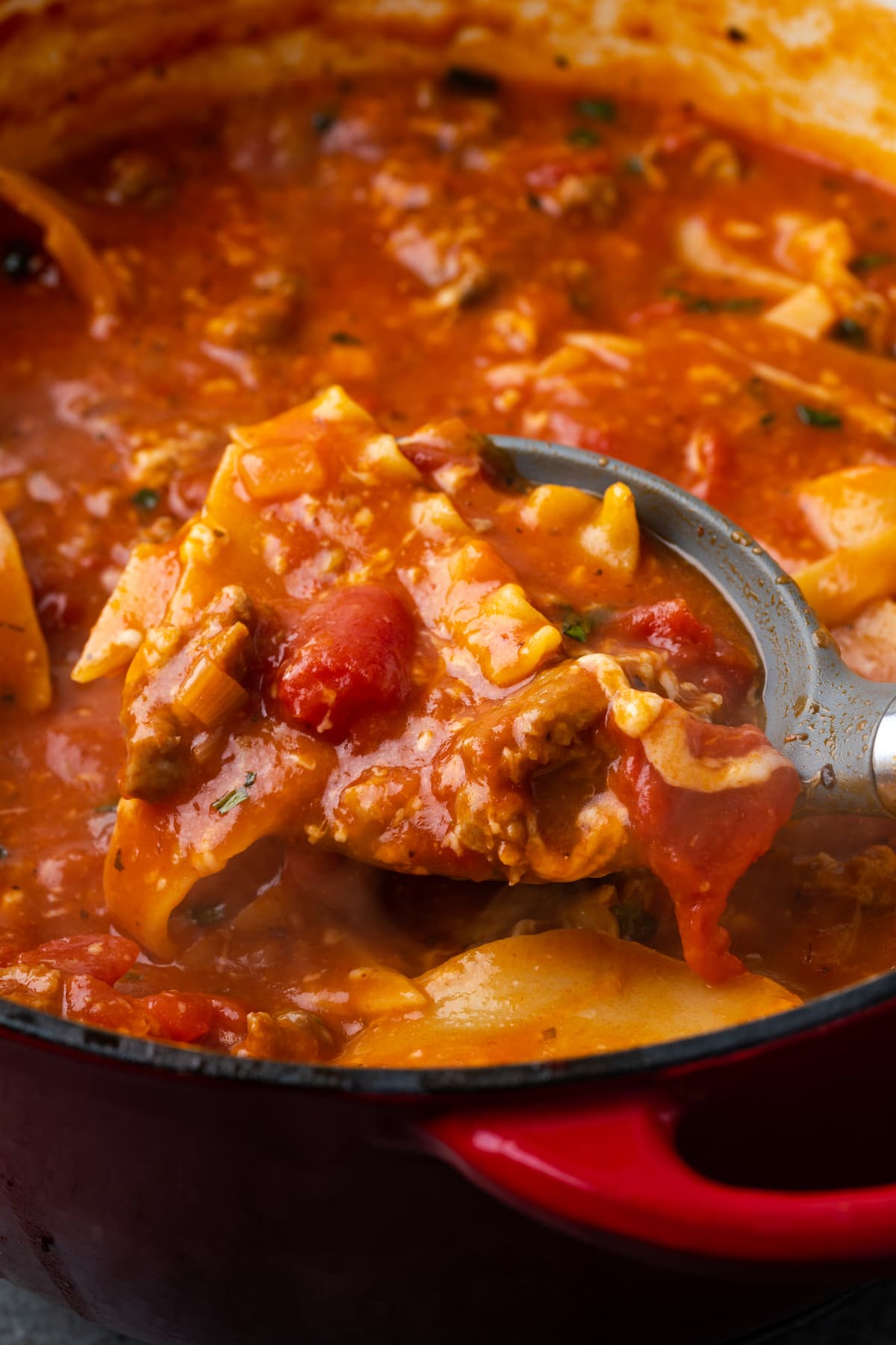 La sopa de lasaña es todo lo que amamos de lasaña casera envuelta en una comida de una sola olla. ¡Prepara esta receta fácil de sopa en 30 minutos o menos! Una cuchara sacando sopa de lasaña de una olla.