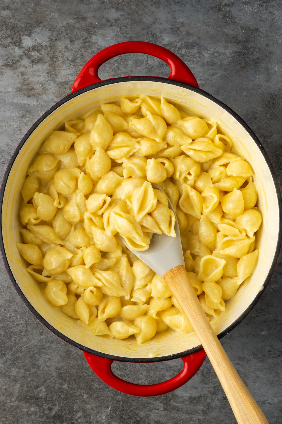 ¡Este Stovetop Mac and Cheese es un alimento reconfortante clásico, hecho en una olla con solo 5 ingredientes! Los macarrones con queso caseros nunca han sido tan fáciles. Pasta de concha cubierta con salsa de queso en una olla grande con una cuchara para revolver.