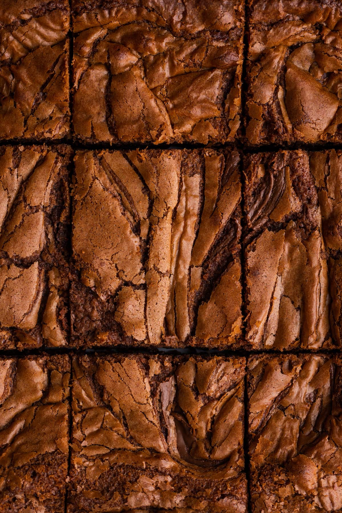 Los brownies caseros de Nutella son ricos, dulces y se arremolinan con crema de chocolate y avellanas. ¡Prepáralos en un tazón con solo 7 ingredientes! Vista aérea de brownies de Nutella cortados en cuadrados.