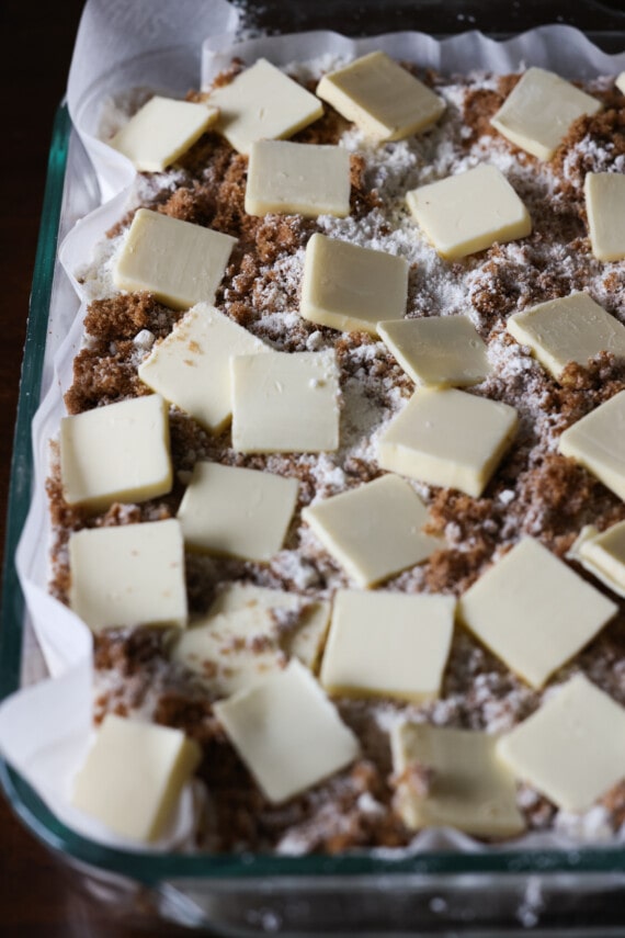 porciones de mantequilla encima del pastel de canela antes de hornearlo