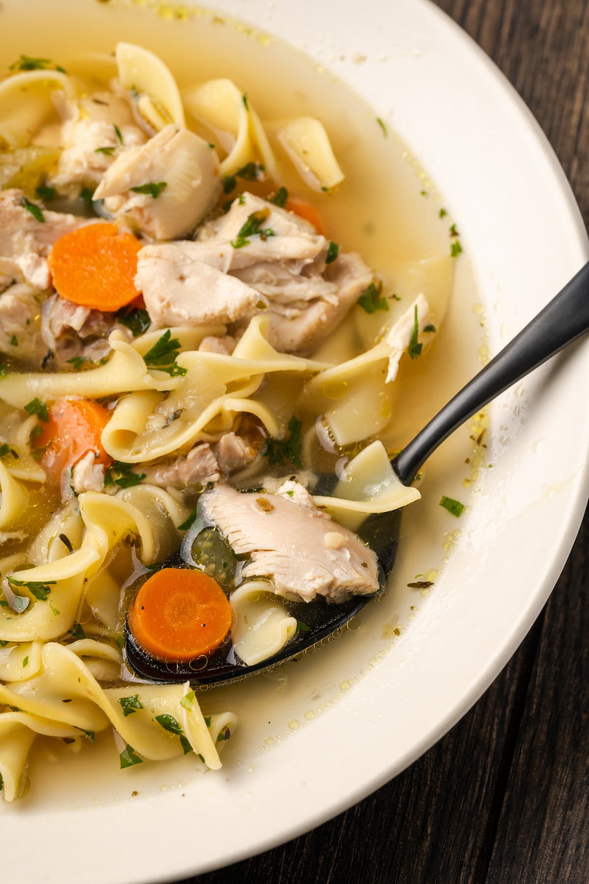 Instant Pot Chicken Noodle Soup es un atajo rápido y fácil para un alimento reconfortante favorito. Rebosante de ingredientes clásicos y toneladas de sabor. Vista aérea de un tazón de sopa de fideos con pollo Instant Pot con una cuchara.