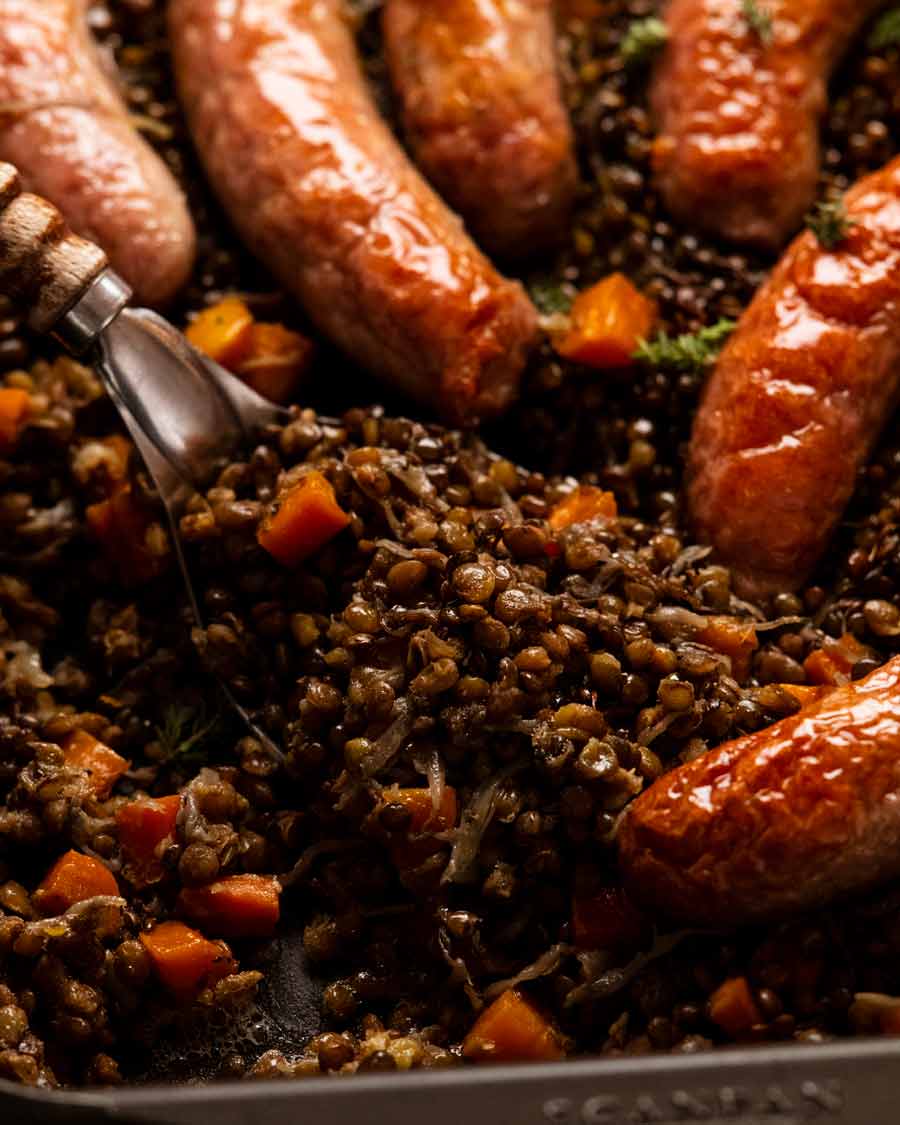 Cerca de una salchicha al horno y lentejas