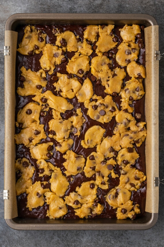 Esta receta fácil de brookies combina brownies de chocolate con galletas masticables con chispas de chocolate. ¡Las galletas de brownie con chocolate son lo mejor de ambos mundos! Brookies sin hornear en una bandeja para hornear forrada de pergamino.