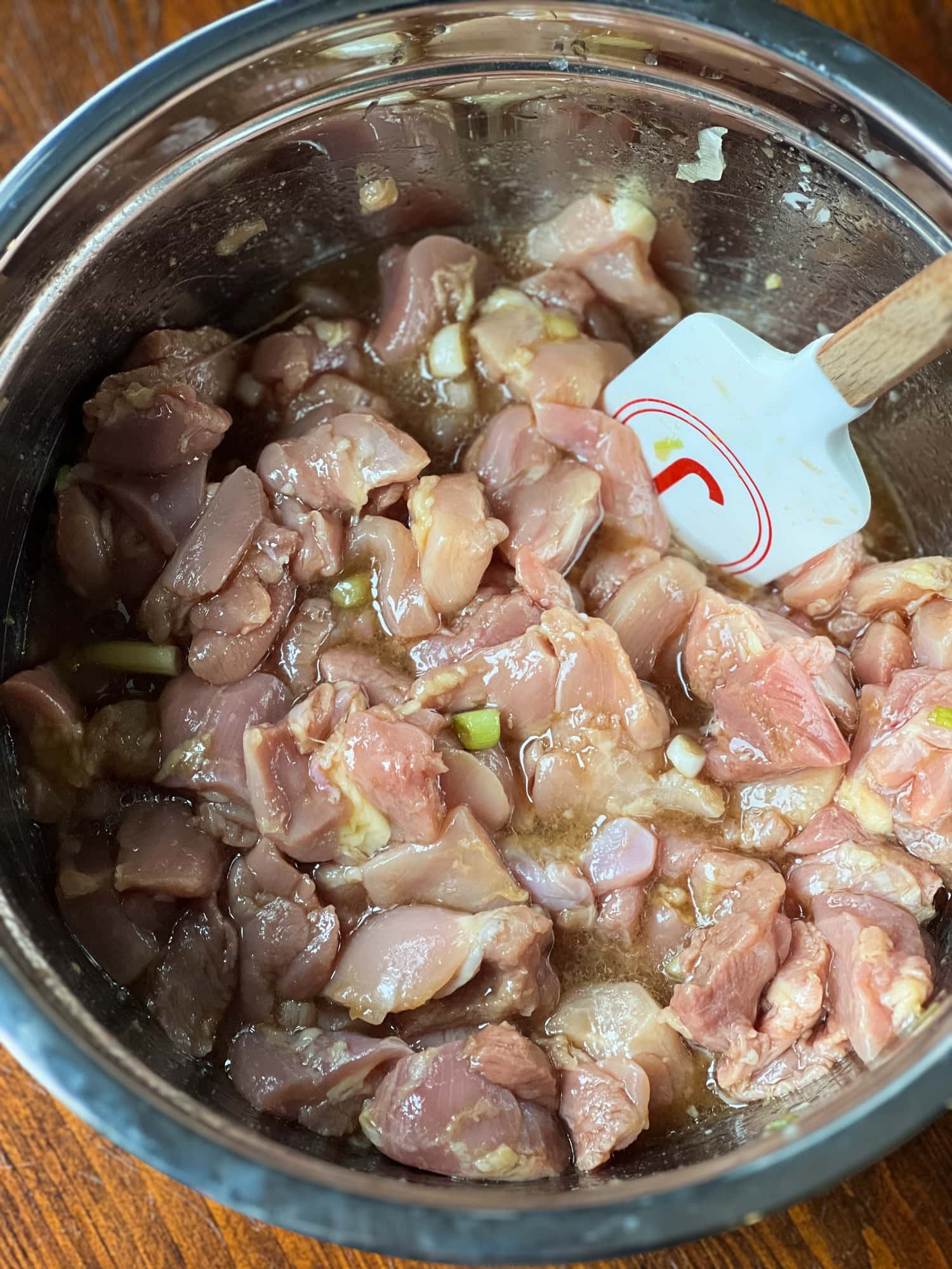 Este sencillo pollo al jengibre está cubierto con un dulce y pegajoso glaseado de soya y jengibre al estilo asiático salpicado de maní. ¡Listo en menos de 20 minutos! Los trozos de muslo de pollo crudos se revuelven en un tazón de adobo de soja y jengibre.