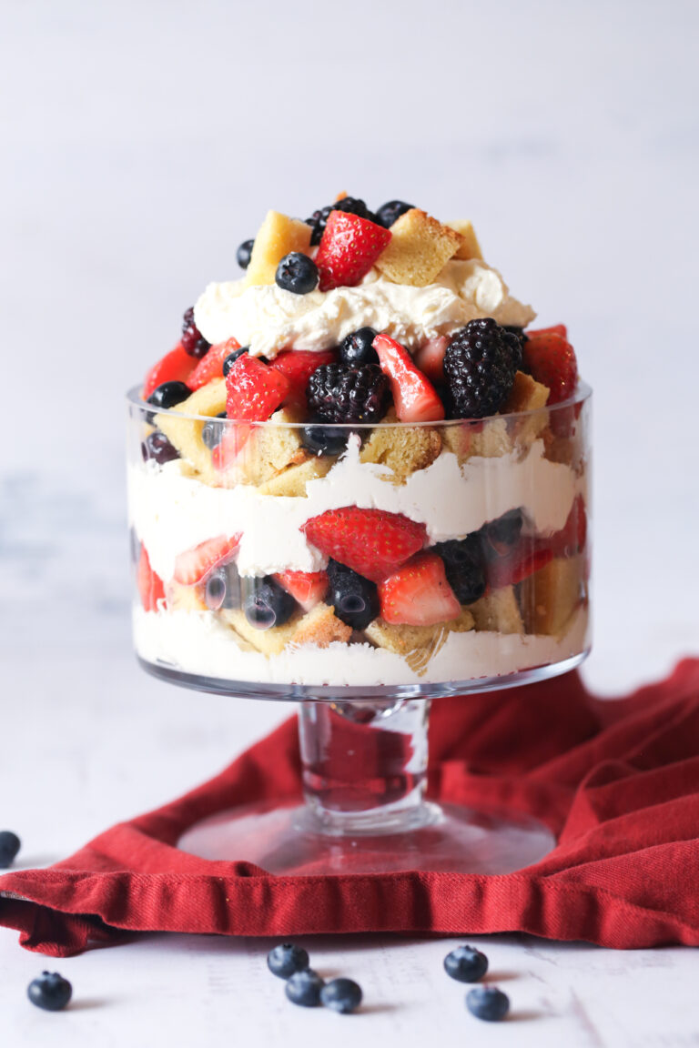 Trifle de pastel de bayas ensamblado en un plato de vidrio.