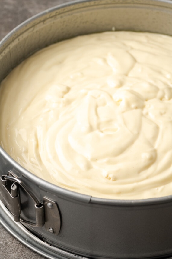 Banana Blondie Cheesecake es un postre fácil con cheesecake de vainilla al horno empapado en caramelo salado, en capas sobre una gruesa banana blondie. Masa de tarta de queso dentro de un molde redondo desmontable.