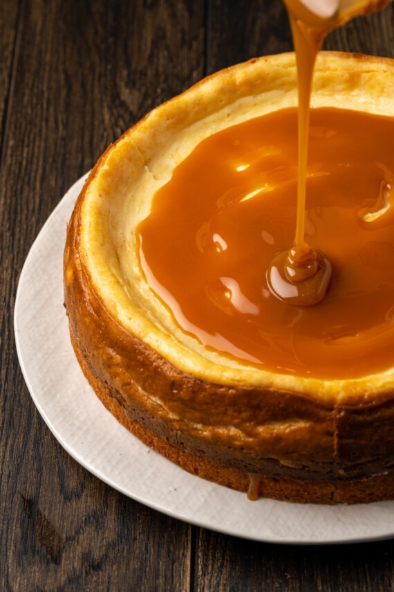 Banana Blondie Cheesecake es un postre fácil con cheesecake de vainilla al horno empapado en caramelo salado, en capas sobre una gruesa banana blondie. Caramelo salado vertido sobre la parte superior de una tarta de queso rubia de plátano horneada.