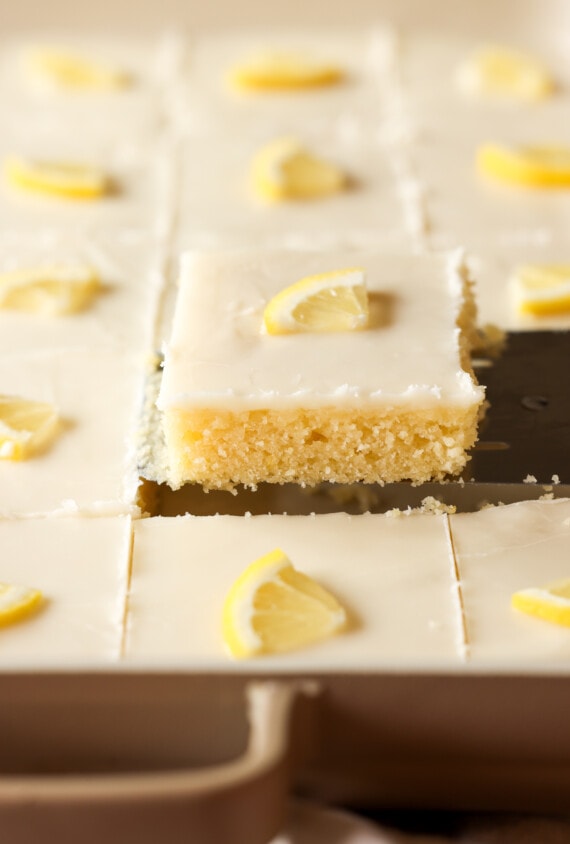 una rebanada de pastel de hoja de limón en una espátula que muestra la vista lateral del pastel