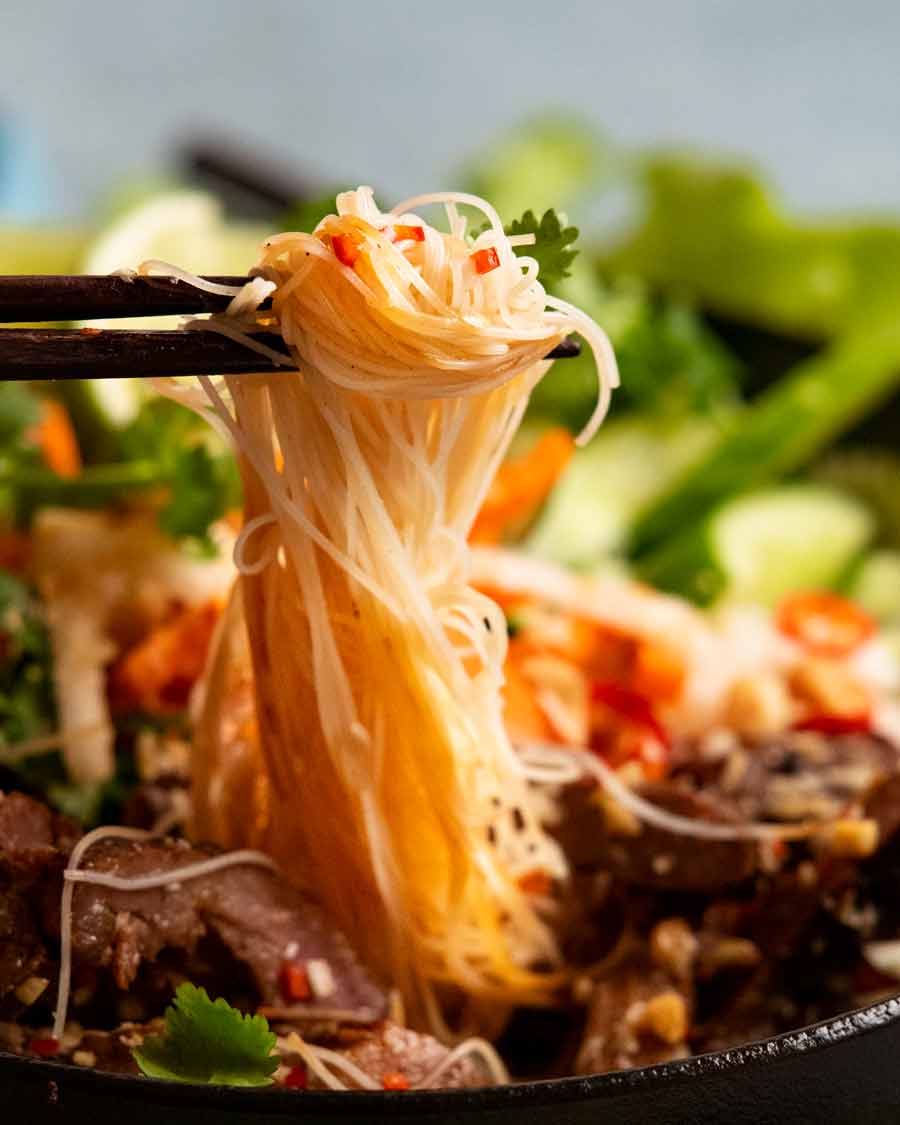 Palillos recogiendo fideos de fideos vietnamitas con cerdo al limoncillo (Bún thịt nướng) tazón de fideos