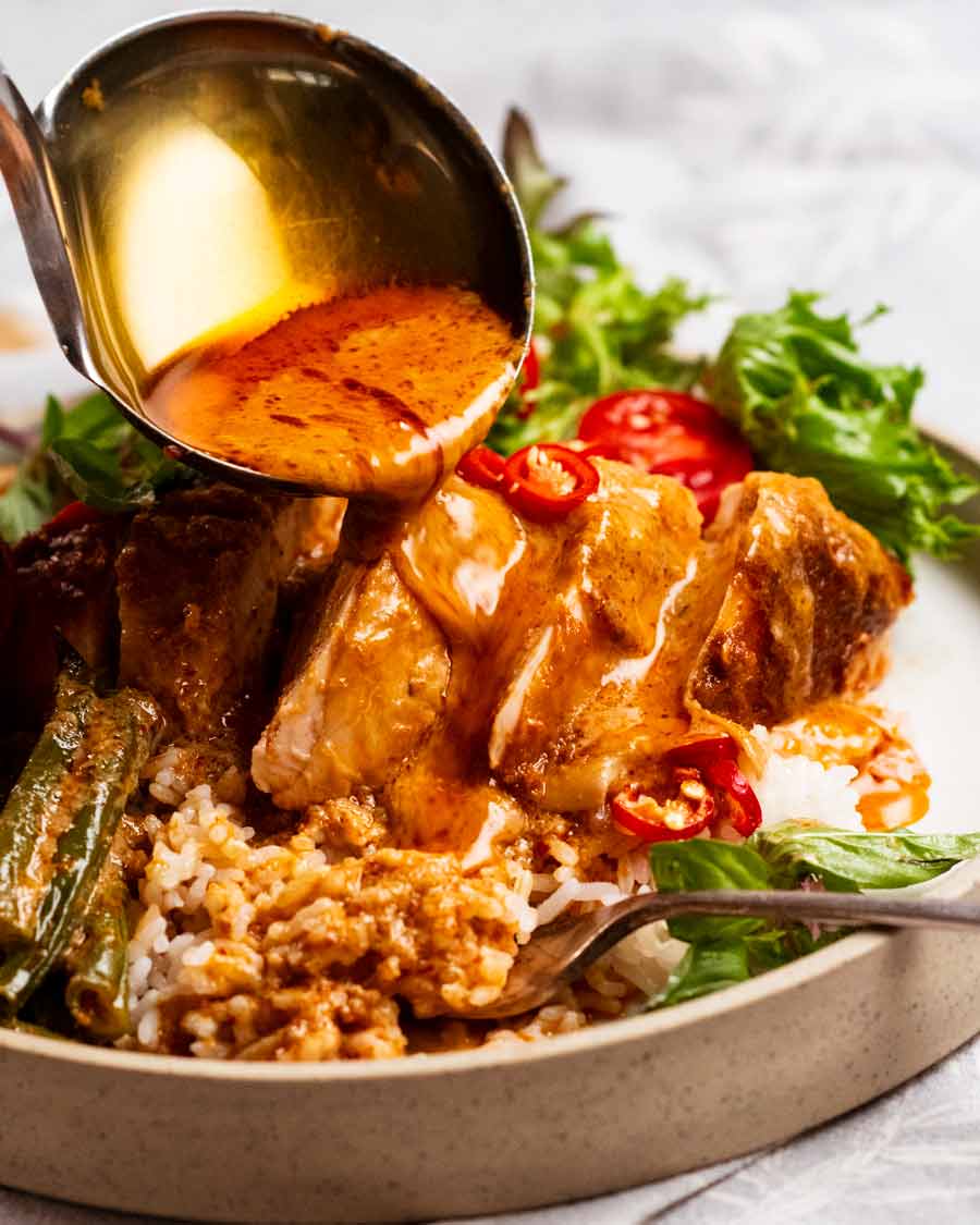 Salsa sobre pollo asado al curry rojo tailandés