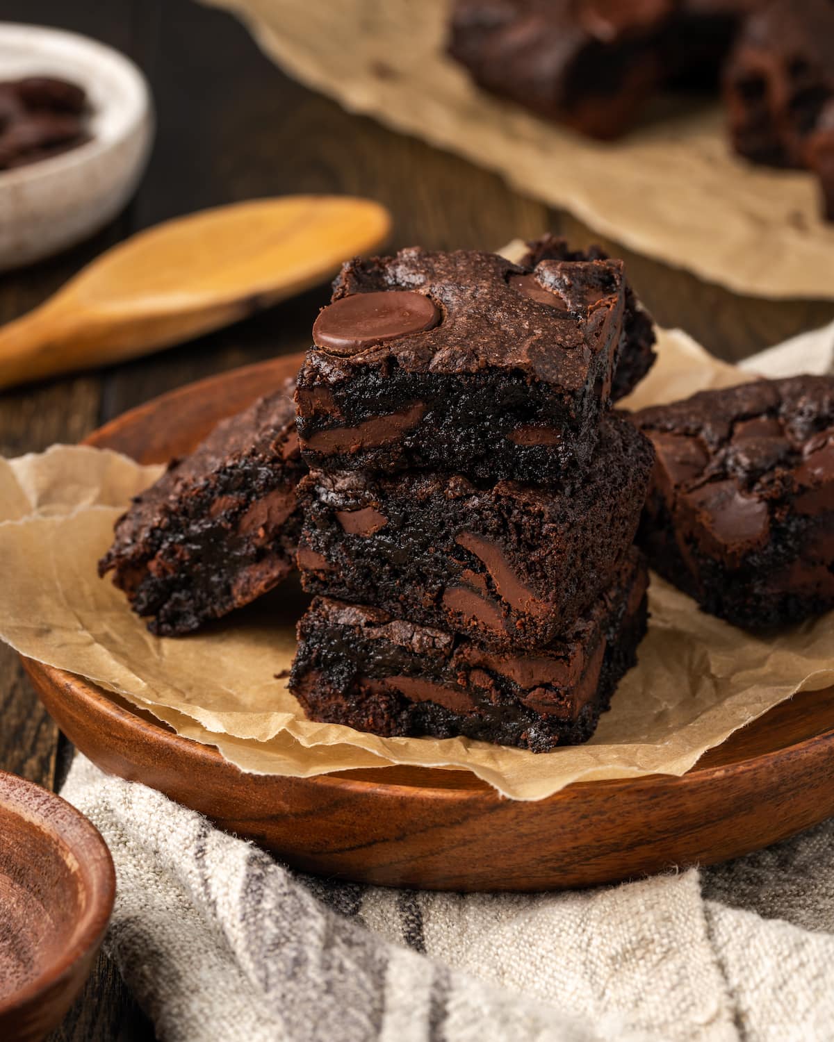 Una pila de brownies de mezcla para pastel de chocolate en un plato forrado con papel pergamino.