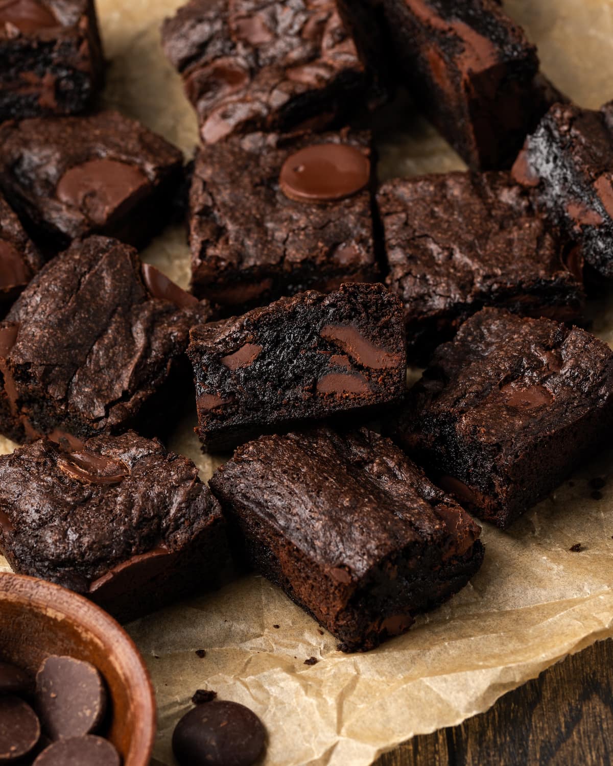 Surtido de brownies de mezcla para pasteles rellenos de trozos de chocolate en una hoja de papel pergamino.