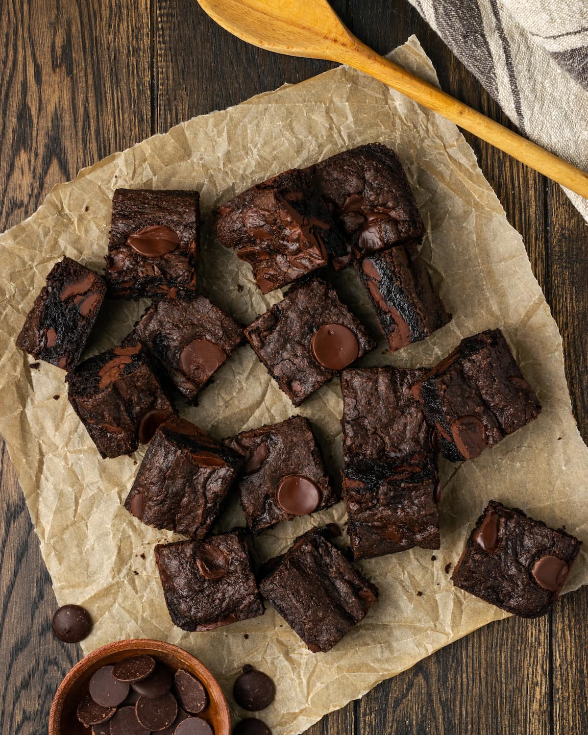 Vista aérea de una variedad de bizcochos de chocolate mezclados para pasteles esparcidos sobre una hoja de papel pergamino.