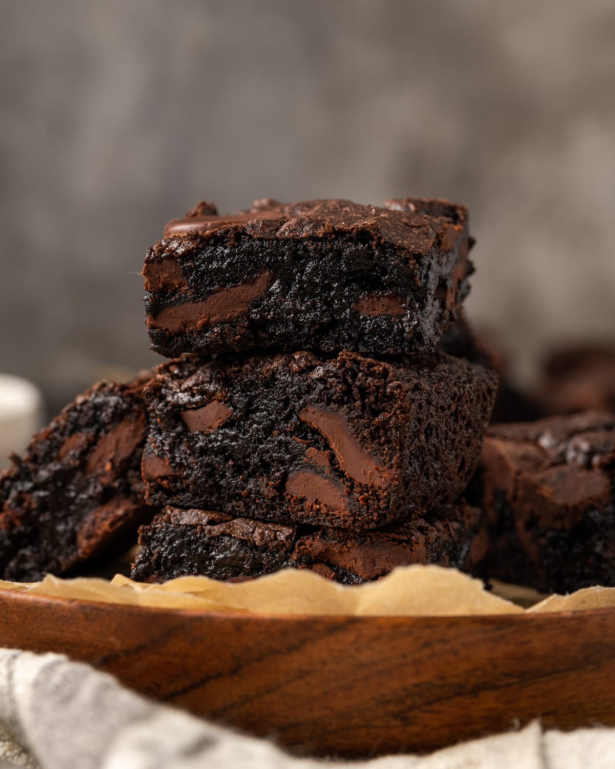 Una pila de brownies de mezcla para pastel de chocolate en un plato forrado con papel pergamino.