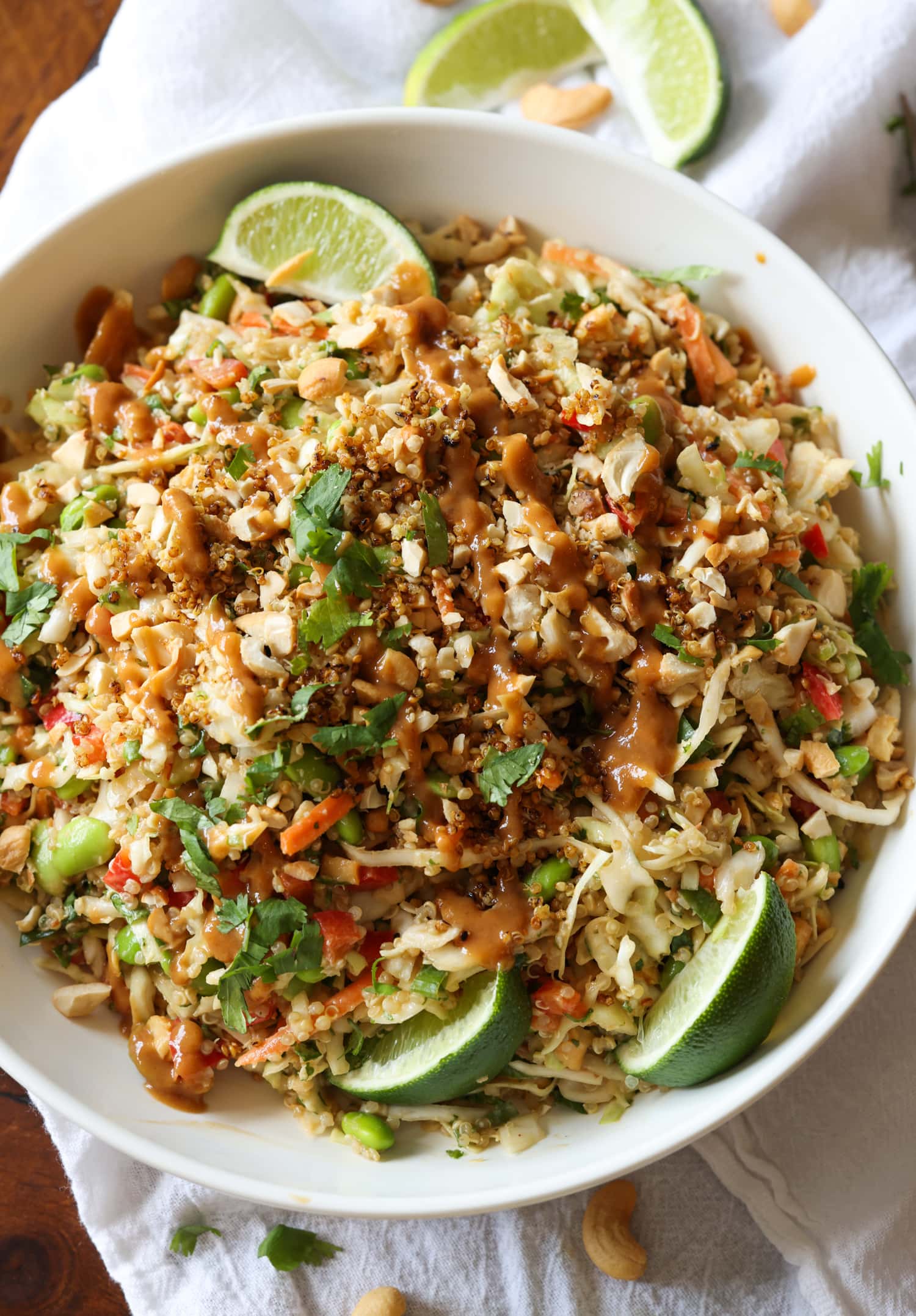 Ensalada tailandesa de quinoa en un bol con rodajas de lima y cilantro picado