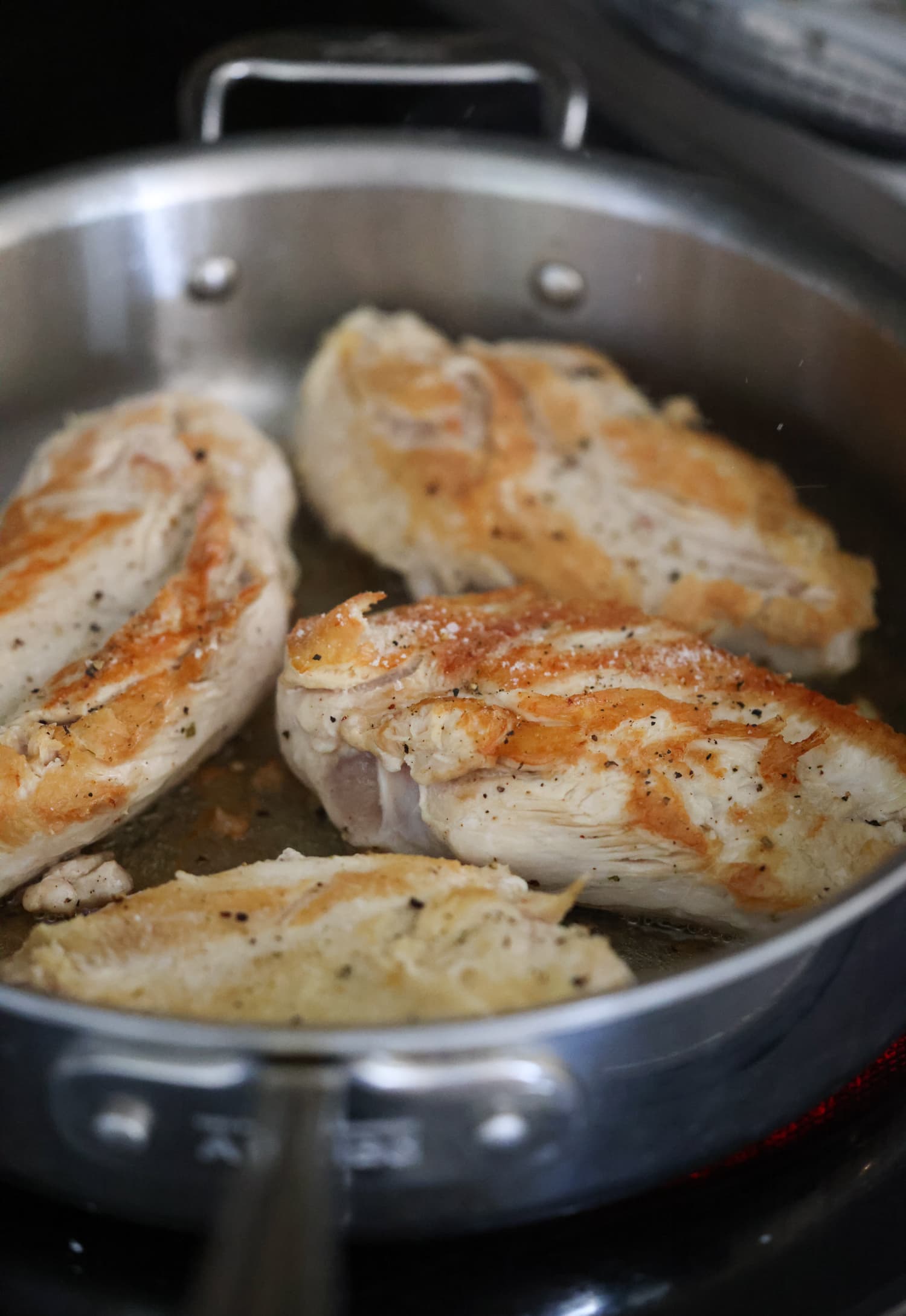 Aprende a hacer pollo desmenuzado de forma fácil y rápida con esta sencilla y deliciosa receta. ¡Perfecto para usar en ensaladas, guisos, tacos y más! pollo sazonado con sal y pimienta en una sartén inoxidable