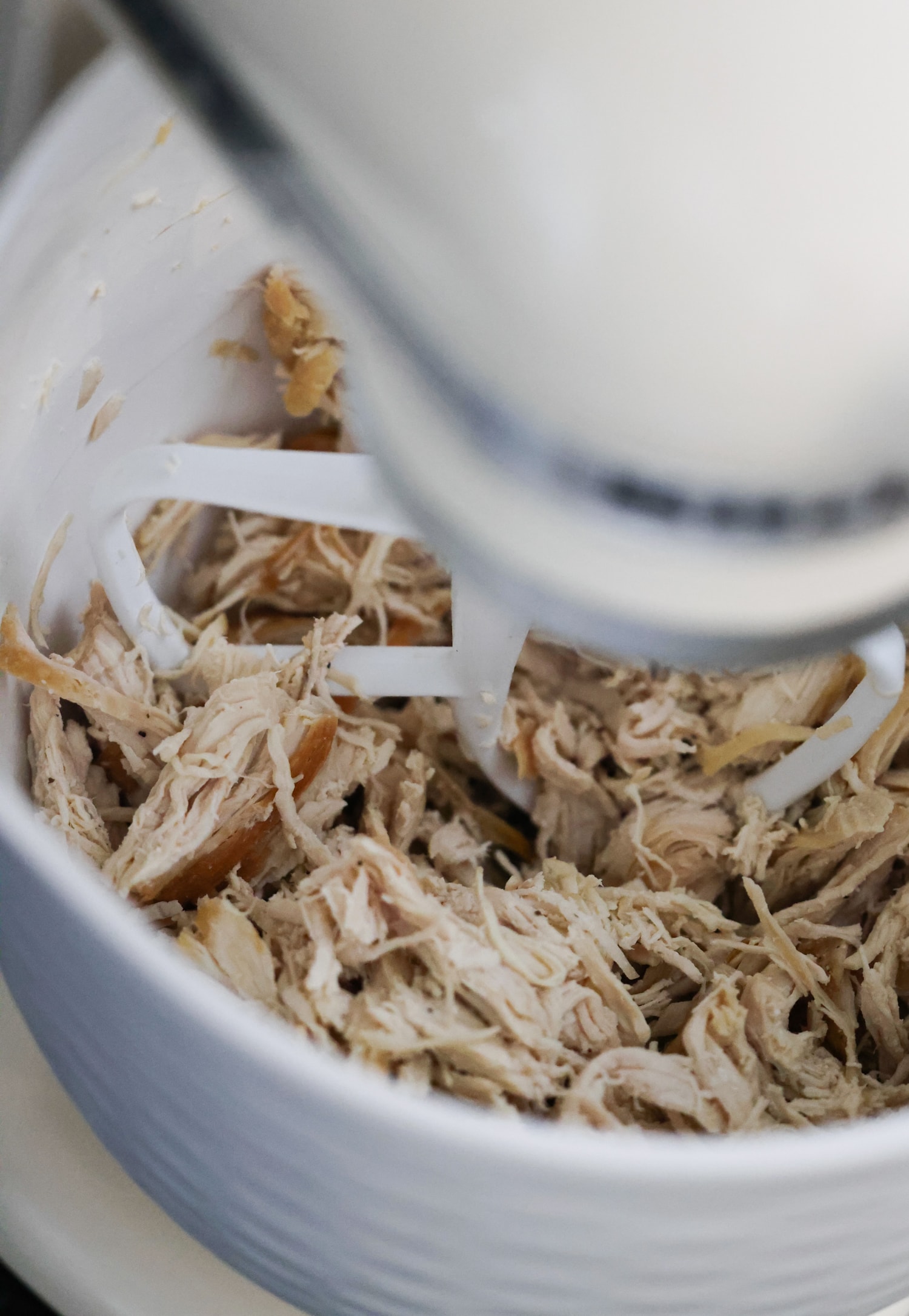 Aprende a hacer pollo desmenuzado de forma fácil y rápida con esta sencilla y deliciosa receta. ¡Perfecto para usar en ensaladas, guisos, tacos y más! Tirar pollo en un tazón para mezclar a baja velocidad