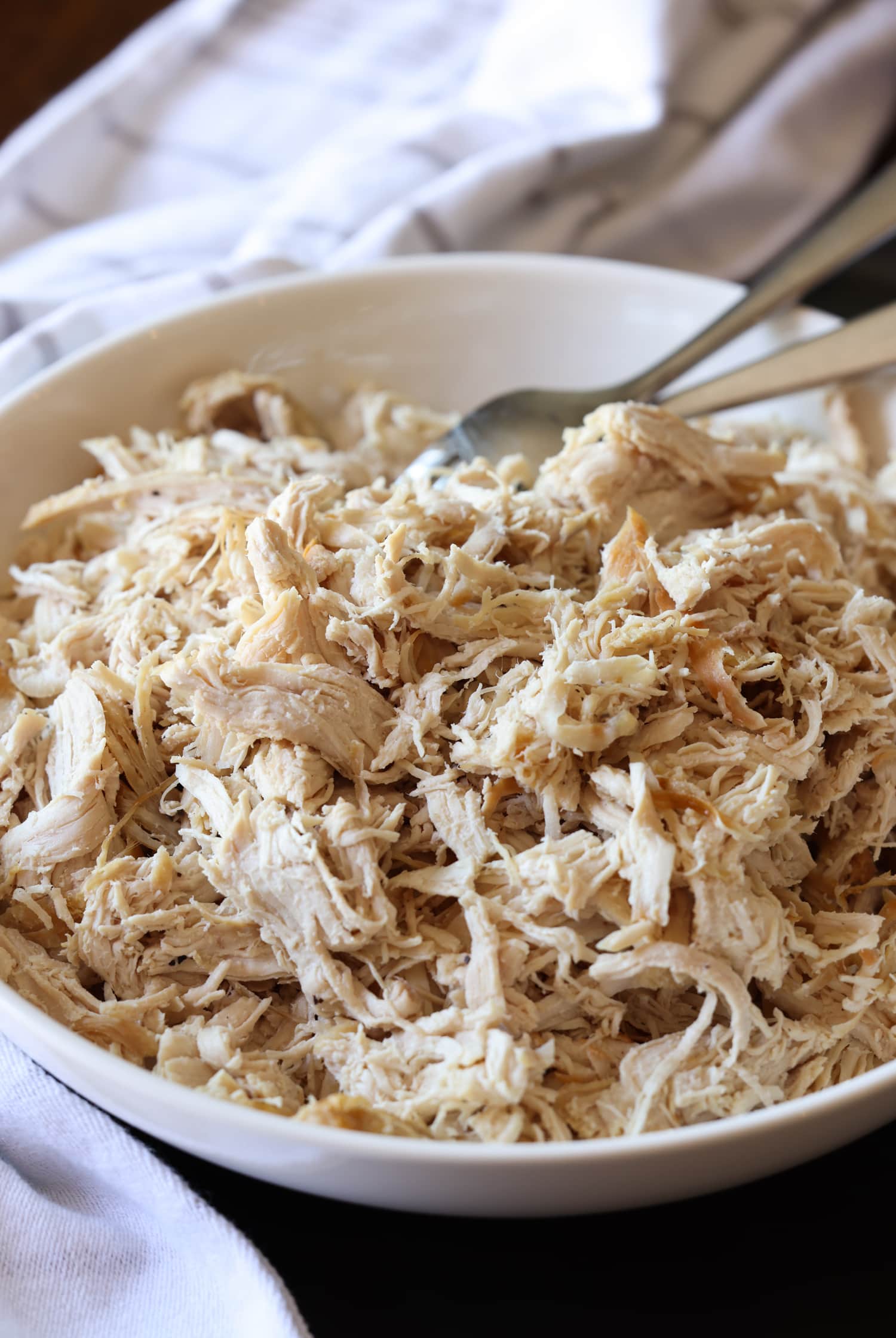 Aprende a hacer pollo desmenuzado de forma fácil y rápida con esta sencilla y deliciosa receta. ¡Perfecto para usar en ensaladas, guisos, tacos y más! pollo cocido y desmenuzado en un bol