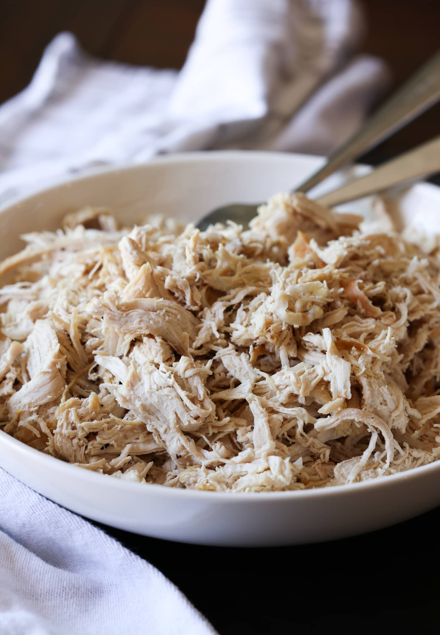 Aprende a hacer pollo desmenuzado de forma fácil y rápida con esta sencilla y deliciosa receta. ¡Perfecto para usar en ensaladas, guisos, tacos y más! tirado de pollo en un tazón