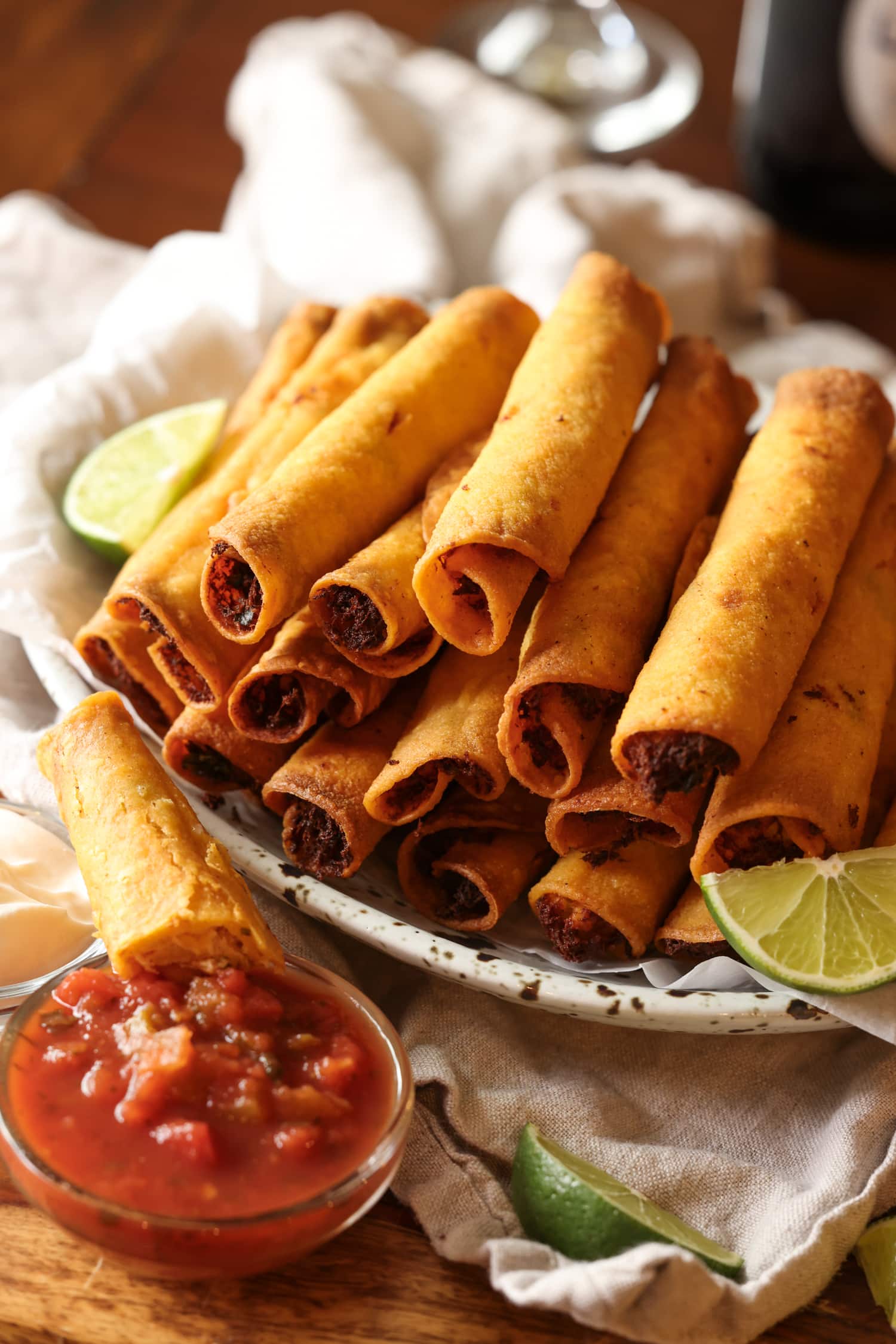 La receta de taquitos de pollo con queso son tortillas crujientes rellenas de pollo, quesos y condimentos, ¡una idea súper fácil para cenar en el área de los taquitos! Taquitos de pollo en bandeja con salsa