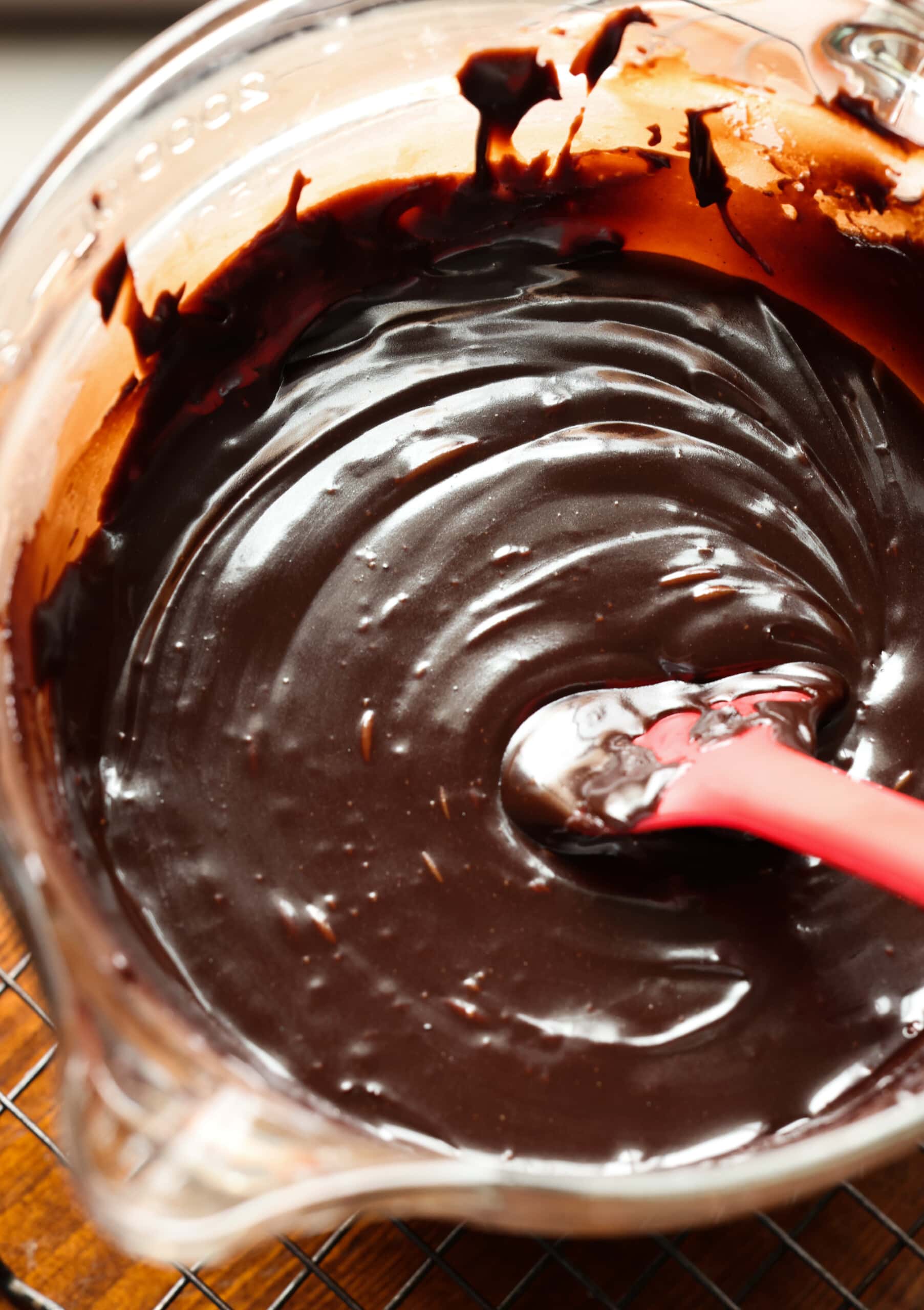 Ganache de chocolate en un recipiente de vidrio con una espátula de goma