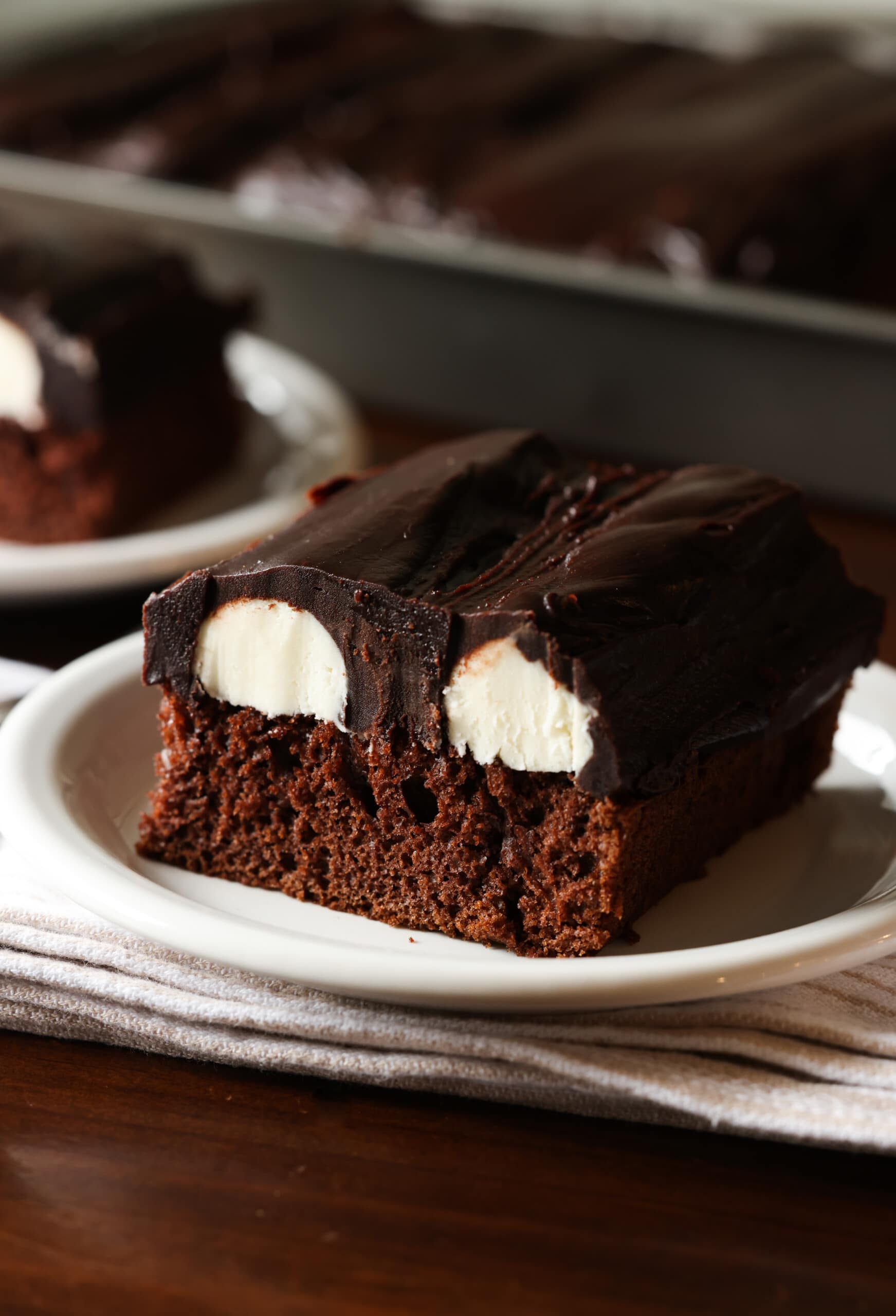 pastel de chocolate del diablo cubierto con crema de mantequilla de vainilla y ganache de chocolate en rodajas en un plato blanco
