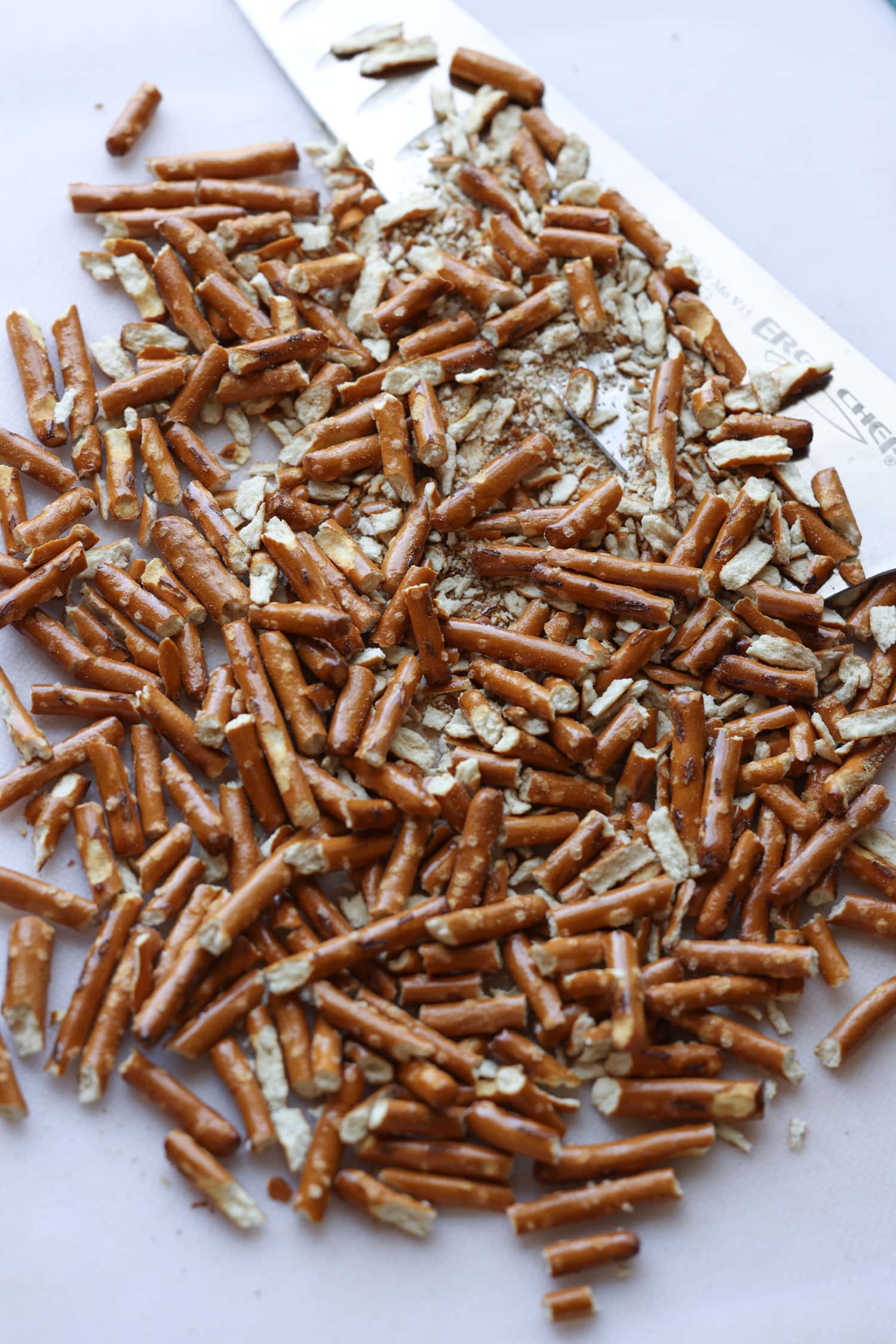 palitos de pretzels picados en una tabla para cortar