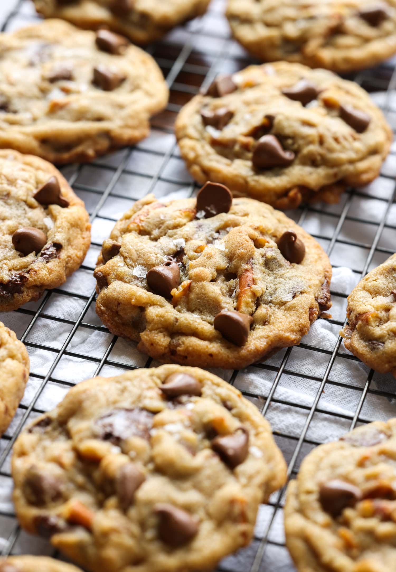 Galletas de fregadero de cocina con pretzels y trocitos de chocolate en la parte superior sobre una rejilla de enfriamiento de alambre