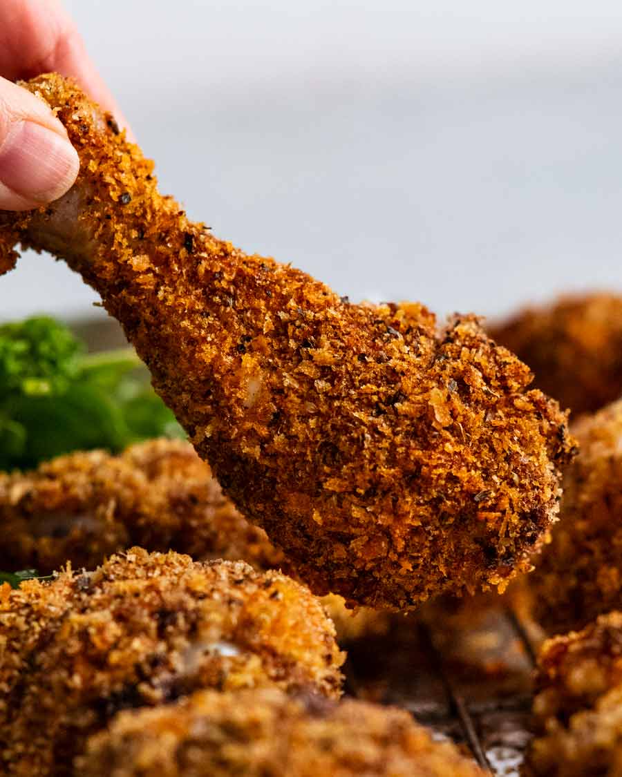 Sosteniendo muslos de pollo desmenuzados crujientes