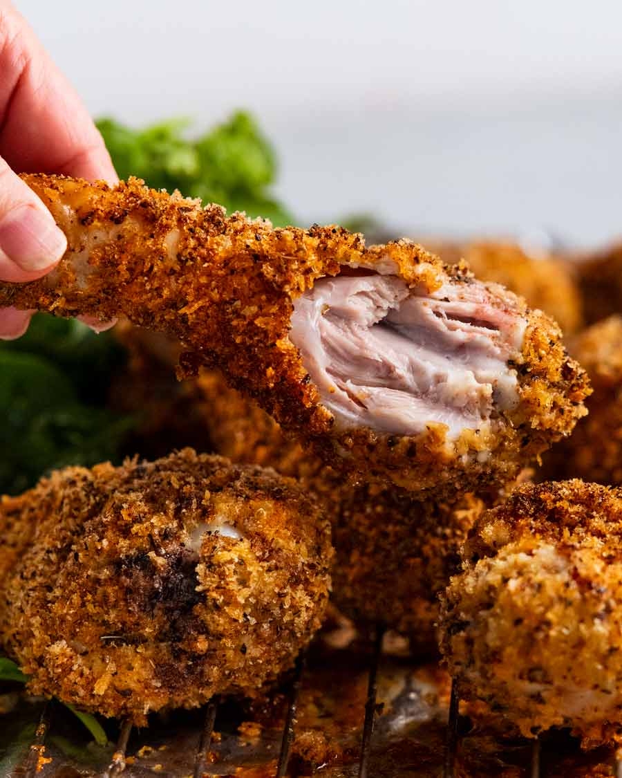 Sosteniendo muslos de pollo desmenuzados crujientes