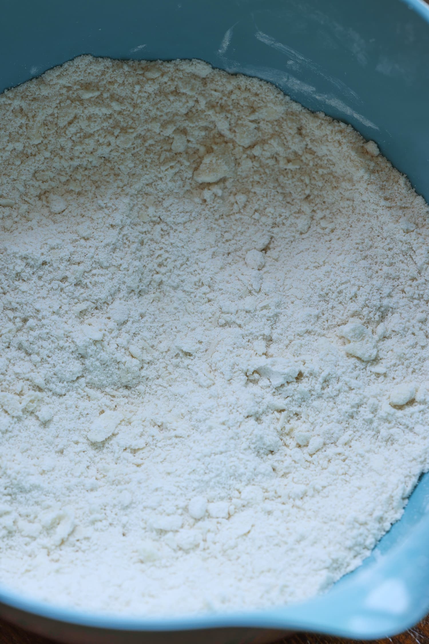 ¡Esta receta fácil de zapatero de arándanos es un postre clásico de verano que debes probar! Los arándanos dulces combinados con una cubierta de galleta mantecosa se hornean hasta que estén burbujeantes y dorados. Un tazón azul con harina en él