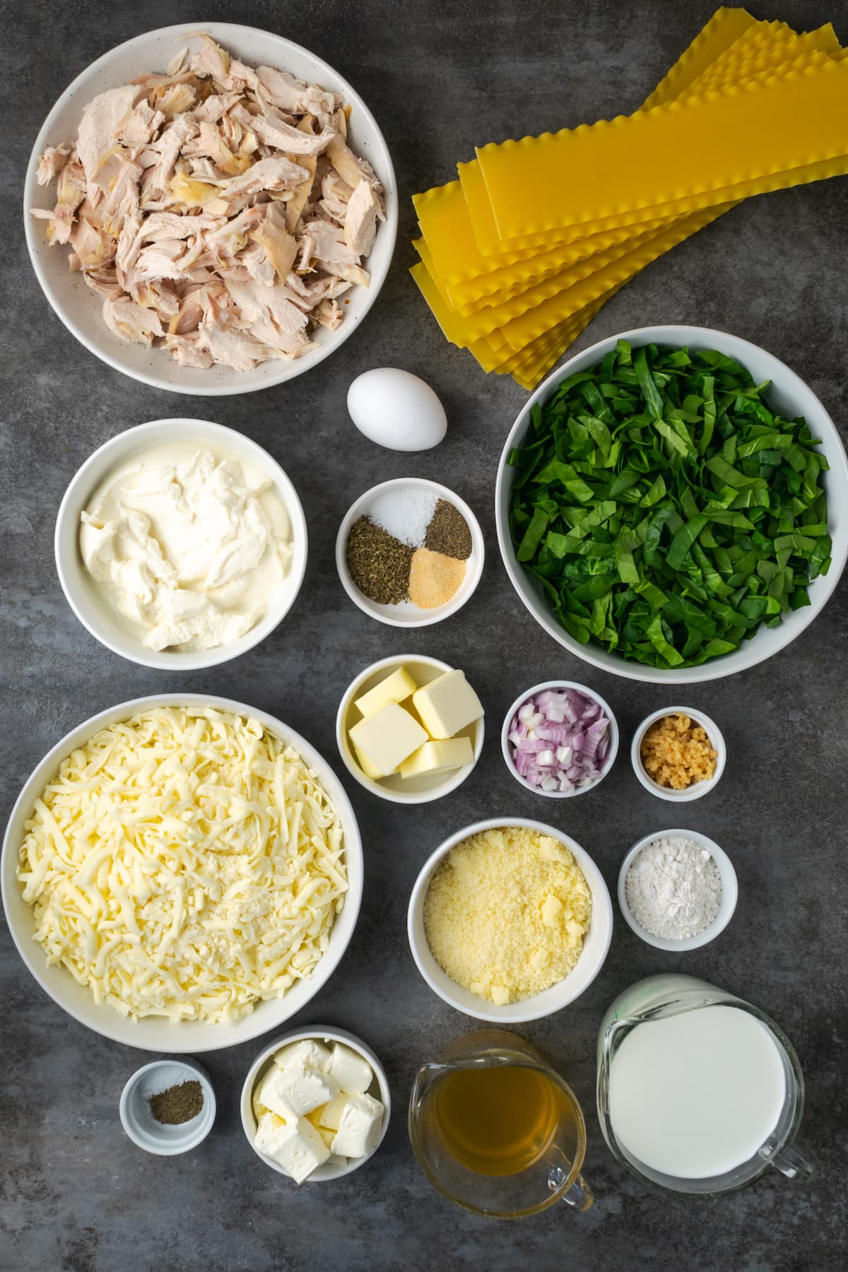 Lasaña cremosa de pollo rebosante de capas de pollo jugoso, fideos tiernos y salsa blanca casera sedosa con abundante queso derretido. Los ingredientes para lasaña de pollo.