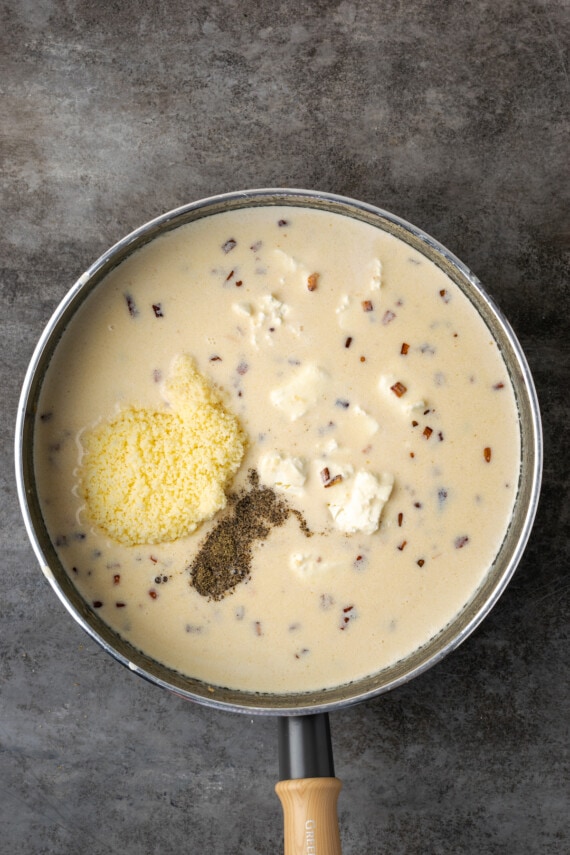 Lasaña cremosa de pollo rebosante de capas de pollo jugoso, fideos tiernos y salsa blanca casera sedosa con abundante queso derretido. Mitad y mitad, queso crema, parmesano y condimentos agregados a la salsa blanca en una sartén.