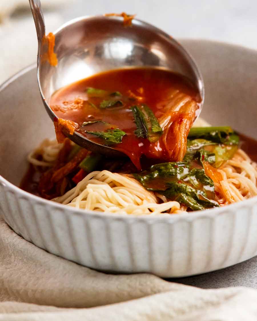 Cucharón de caldo sobre sopa de fideos coreana picante